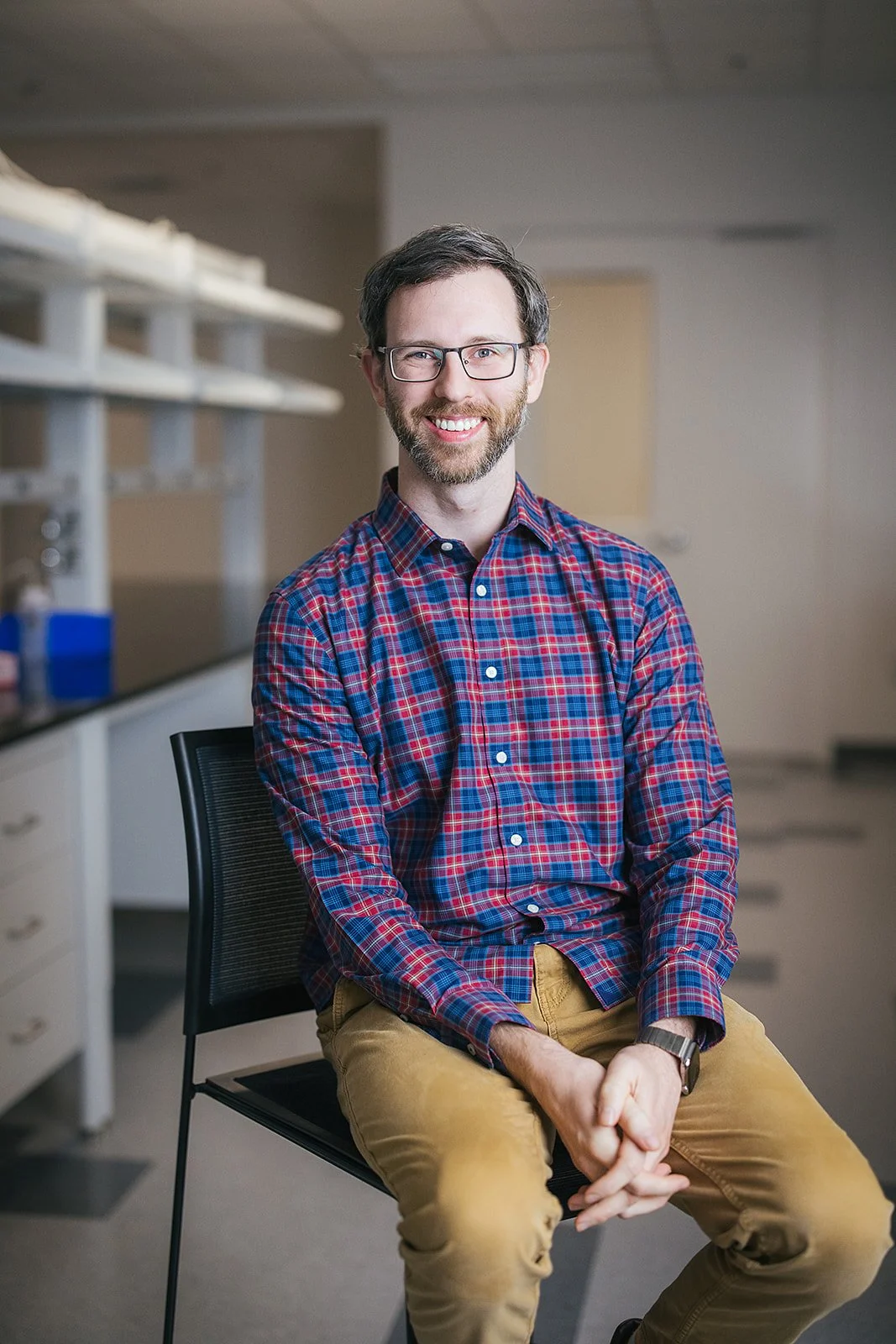 ManInRedAndBluePlaidShirtSittingInLab