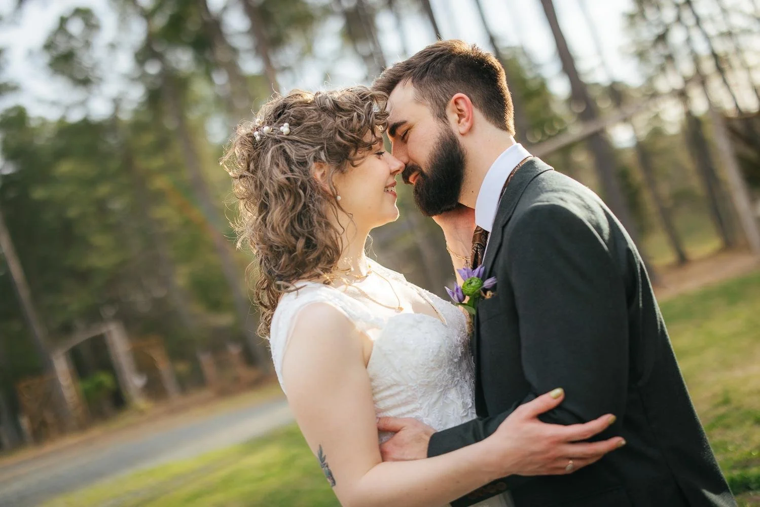 Bride and groom sharing an almost-kiss portrait in the pine trees at Honeysuckle Tea House — soft golden light filtering through the pines — Chapel Hill NC