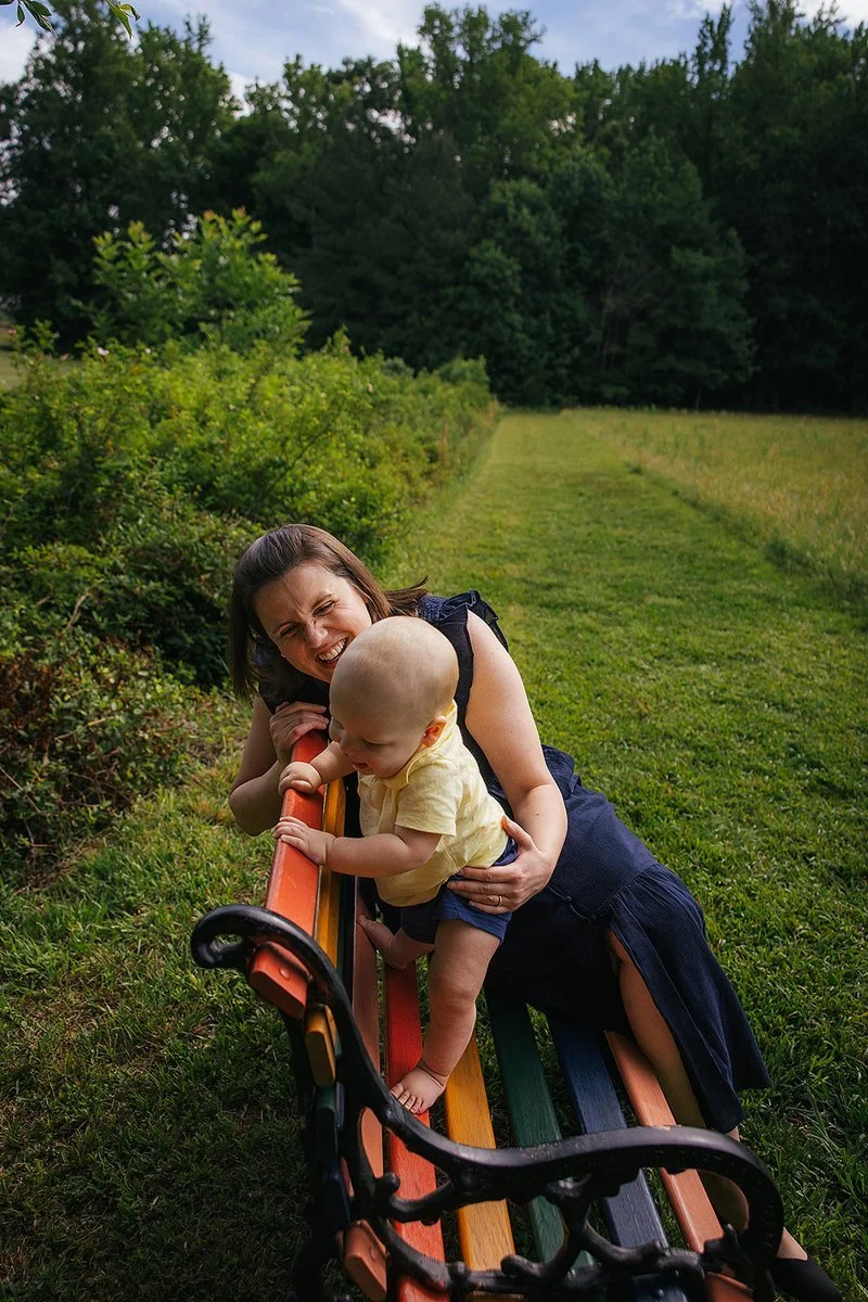 Mom Sitting on Colorful Bench with Baby in front of grasses at Blackwood Farm Park