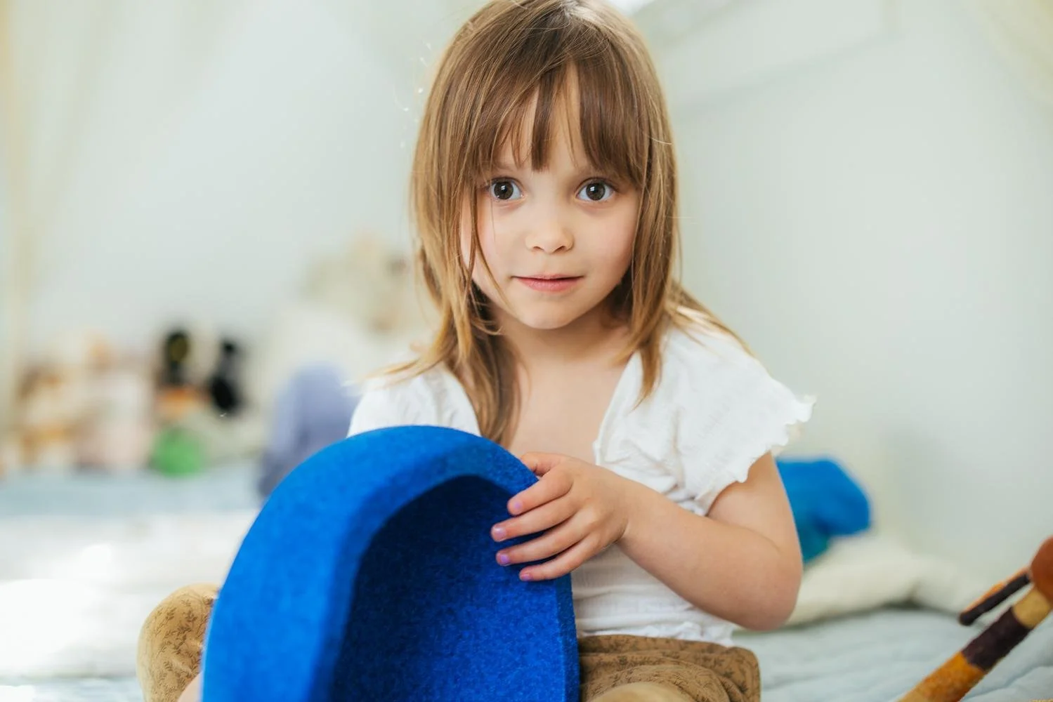 Portrait of a toddler girl in her bedroom looking at the camera during a Durham NC lifestyle newborn session
