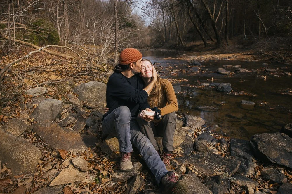 Couple Lovingly Snuggling by Creek During Durham NC Photography Session