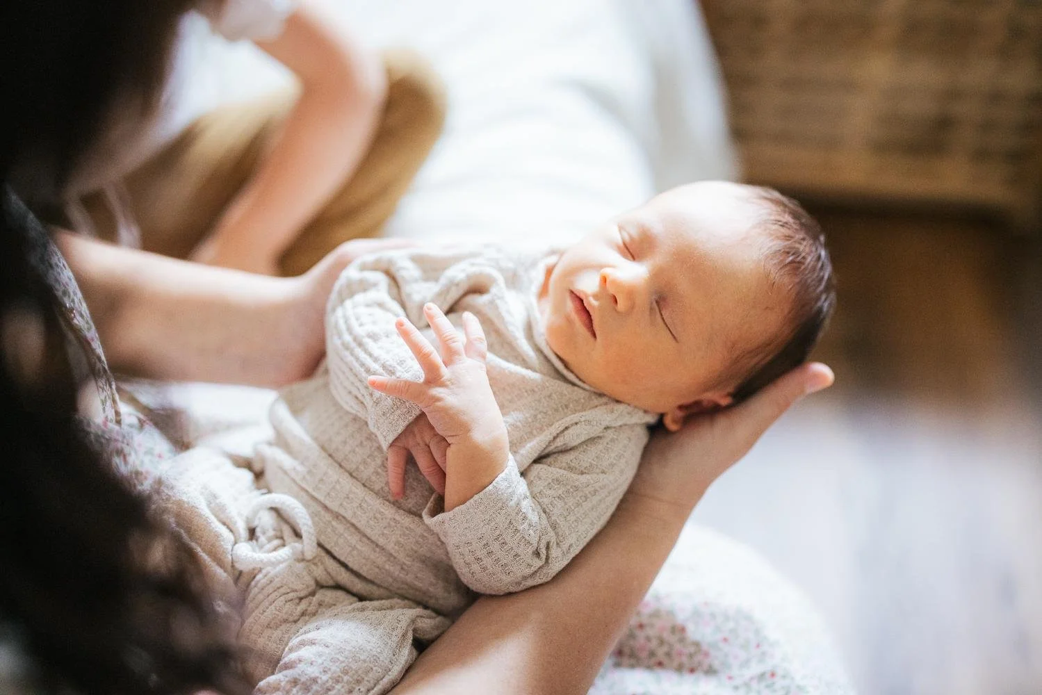 Sleeping newborn in waffle clothing set held by mother for a newborn photoshoot in Durham NC