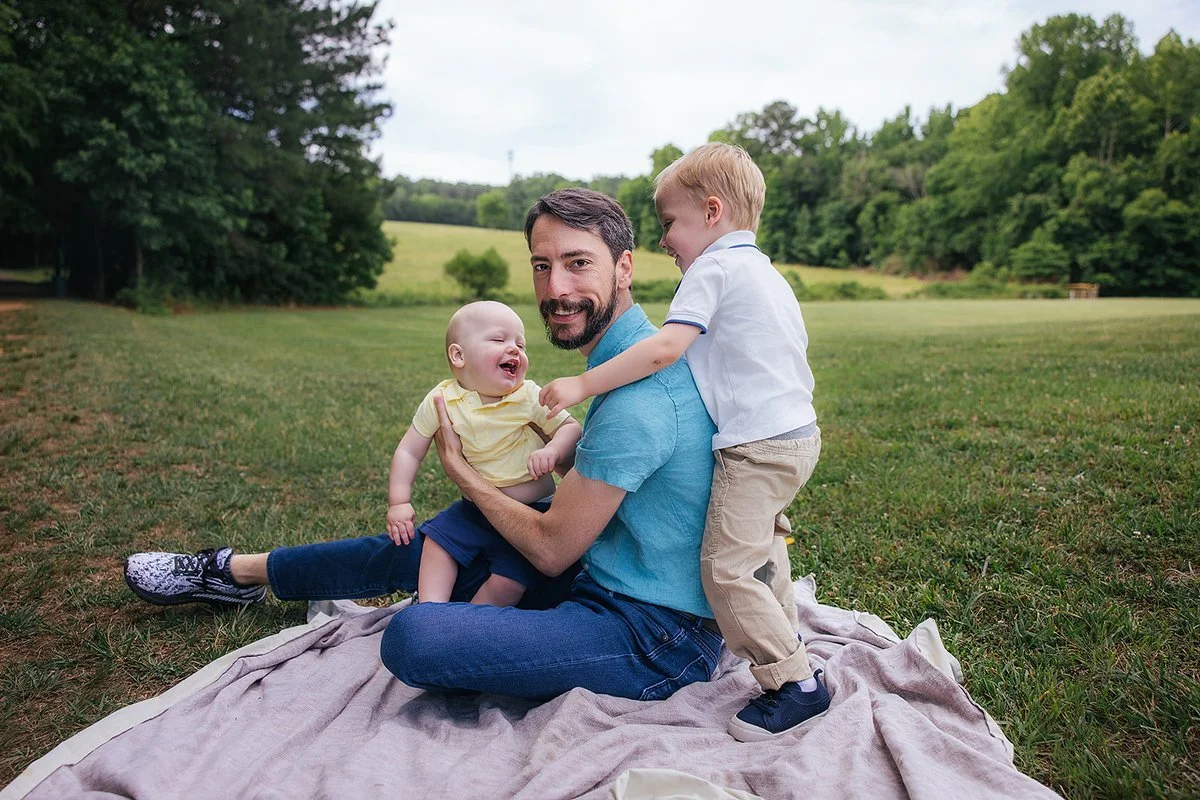 Dad with Young Children in Grass In Blackwood Farm Park