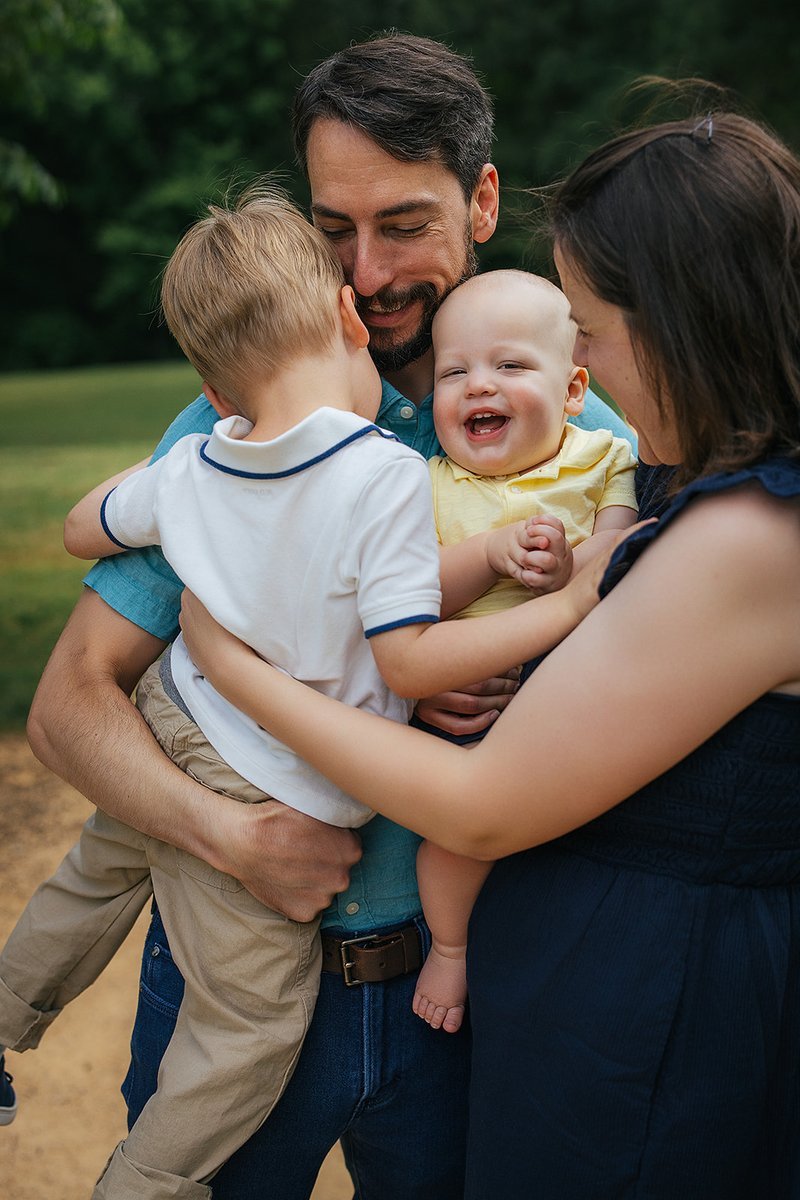 Parents and kids playing and laughing in the grass during an outdoor family session in Chapel Hill
