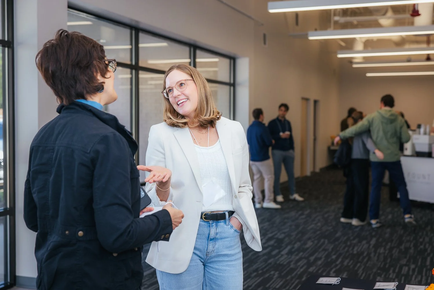 Two women in engaged conversation at a corporate networking event at Longfellow Triangle LIFE campus, Raleigh NC Research Triangle Park area