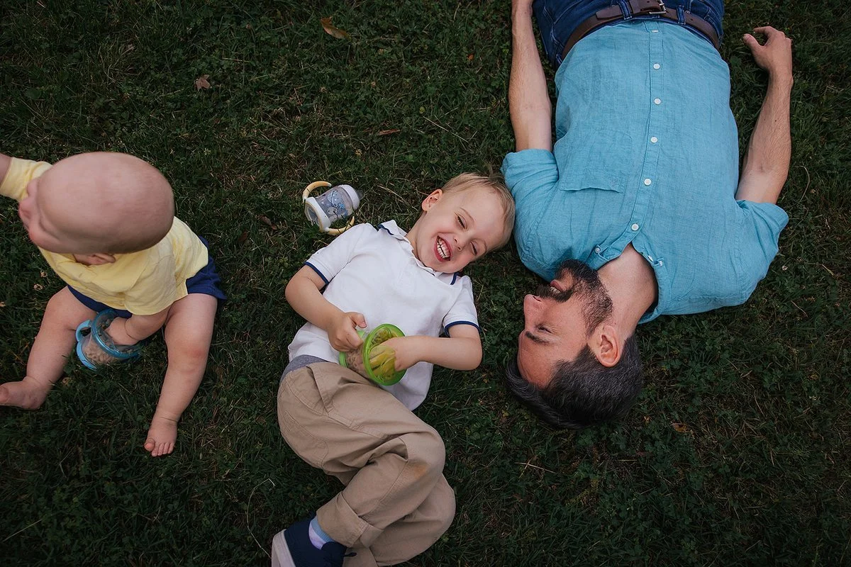 Kids laying and laughing in grass at Blackwood Farm Park in Chapel Hill