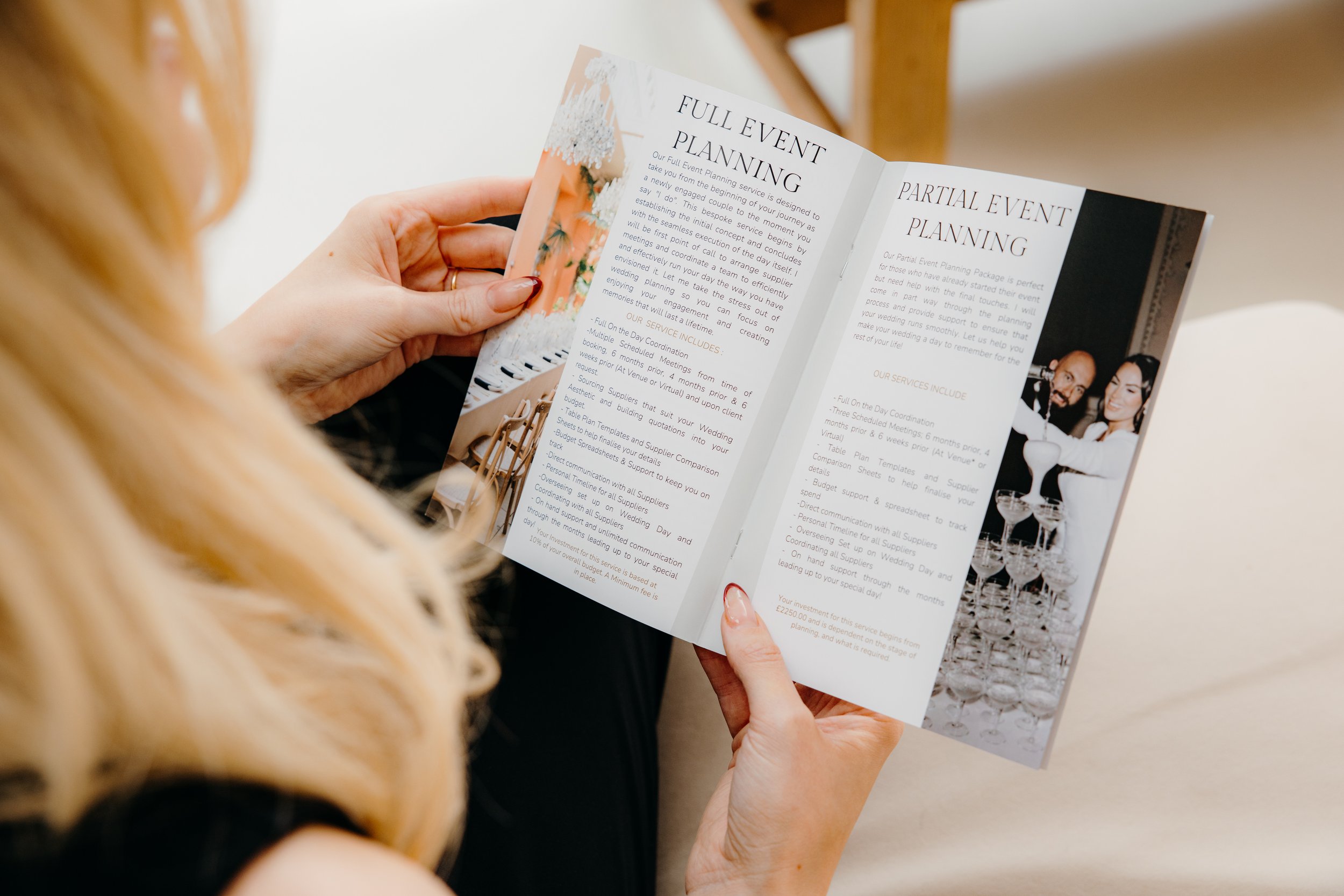 A woman with blonde hair reading a wedding planning brochure that has text and a picture of a wedding cake with champagne glasses. Personal Branding by Lucy Rebecca Photography.