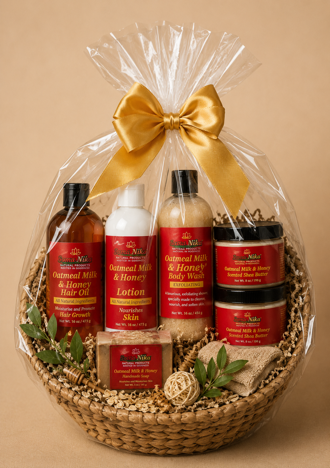 A gift basket wrapped in clear plastic with a gold bow contains skincare and soap products labeled 'Oatmeal Milk & Honey' and made by Soma Nika, including lotion, body wash, hair oil, shea butter, and handmade soap, decorated with green leaves and natural ornaments.