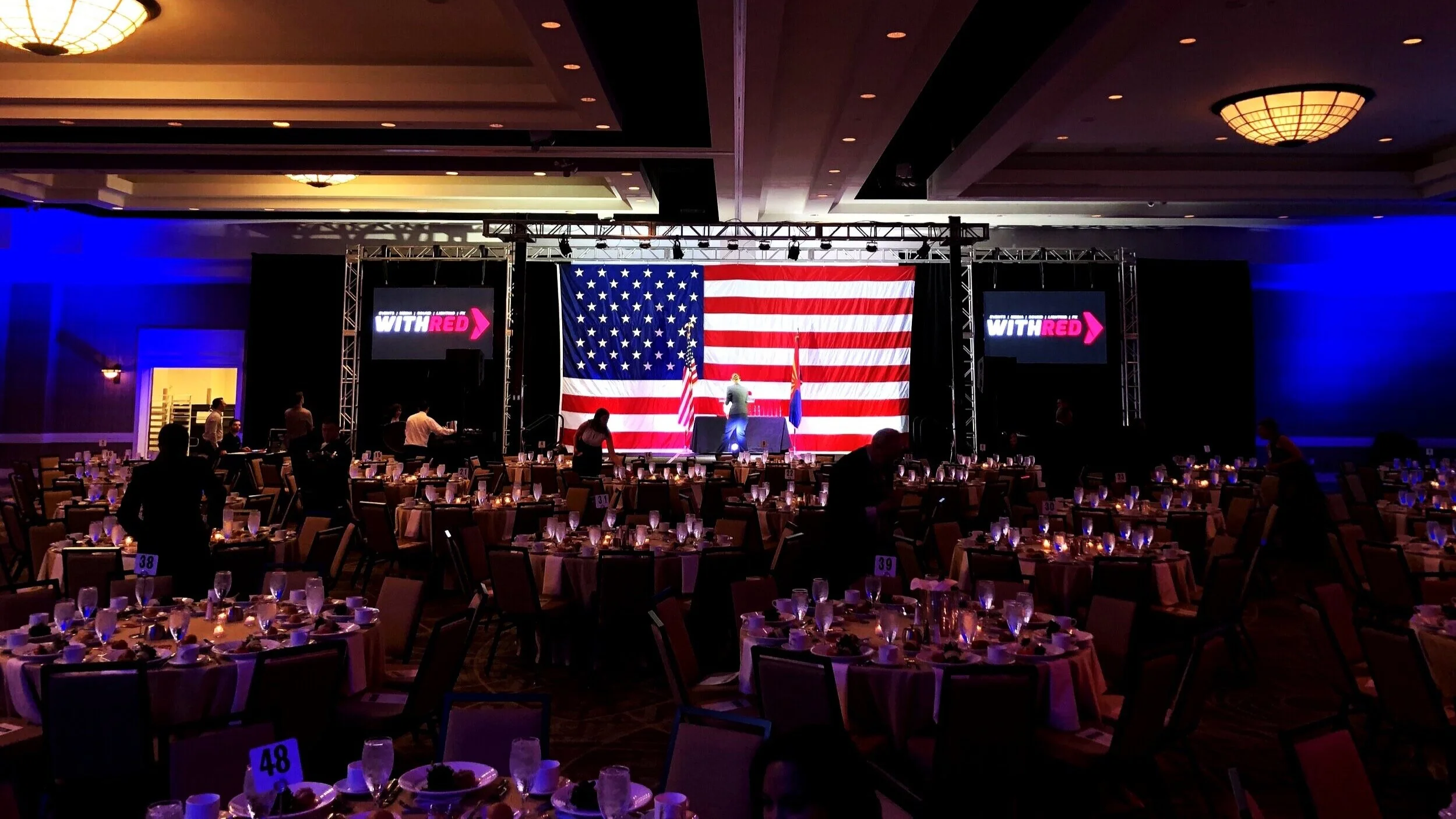 A Private political dinner with LED wall, stage lights, and podium.