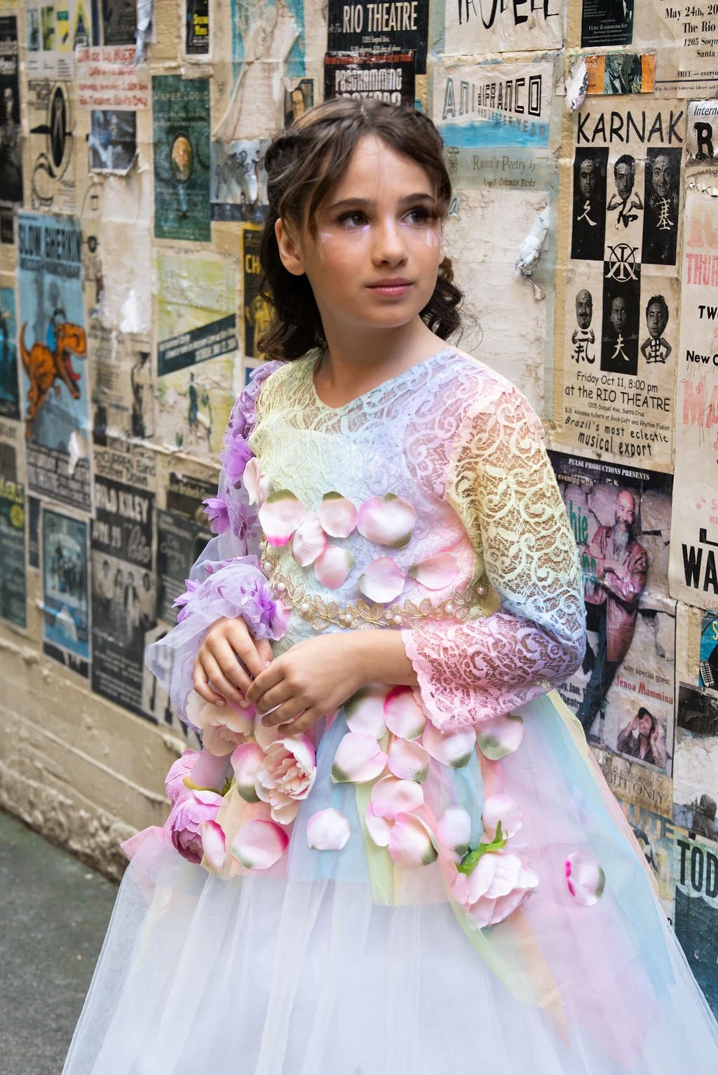 Student designer walks the FashionTeens Santa Cruz 2025 runway in a handmade ocean-inspired gown featuring layered blue and teal tulle and a sequined bodice, evoking waves and coastal elegance.
