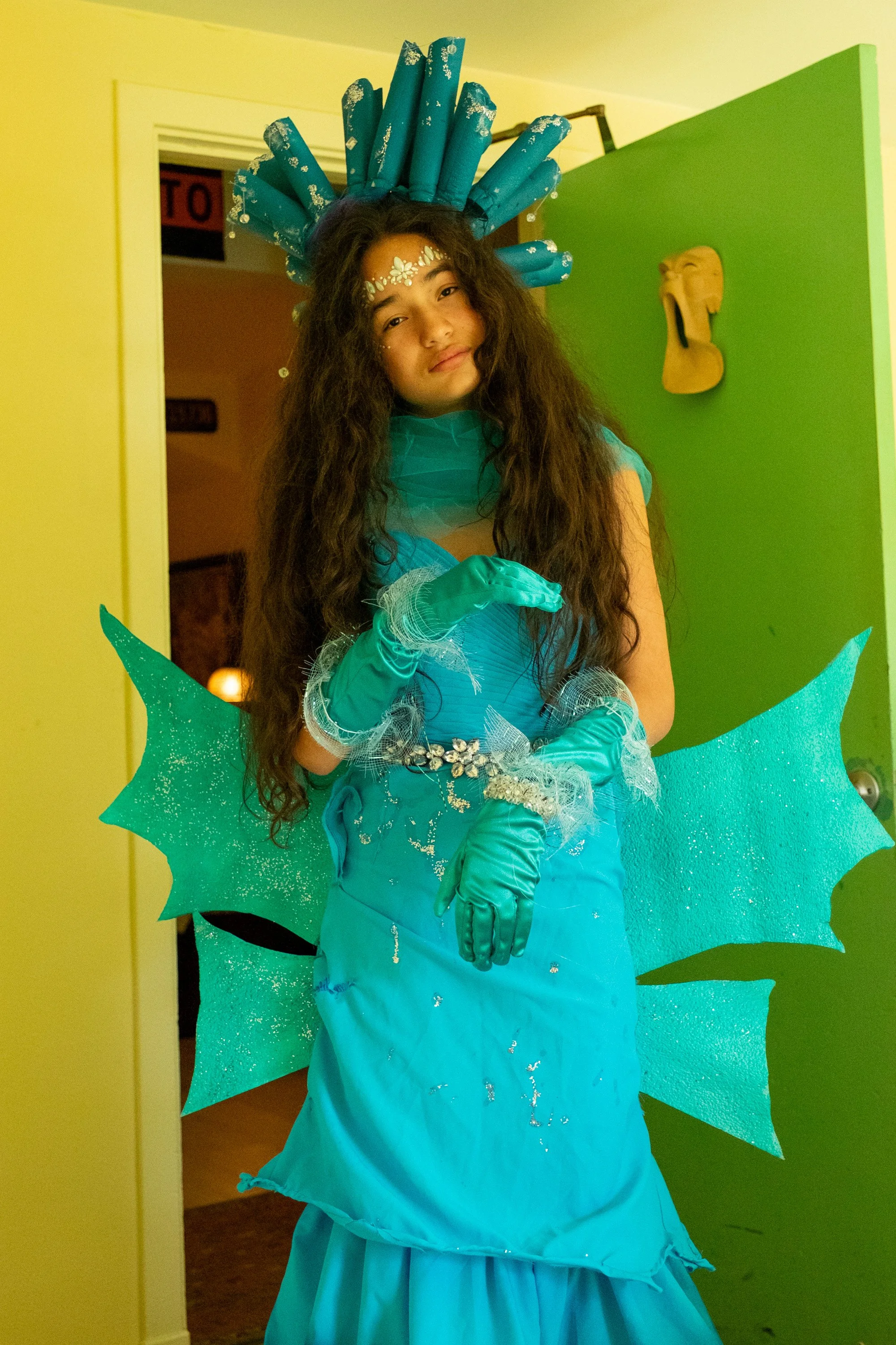 FashionTeens Santa Cruz student runway look inspired by ocean awareness, designed as a jellyfish with a large hat decorated with hanging cans and trash to highlight pollution and sustainability