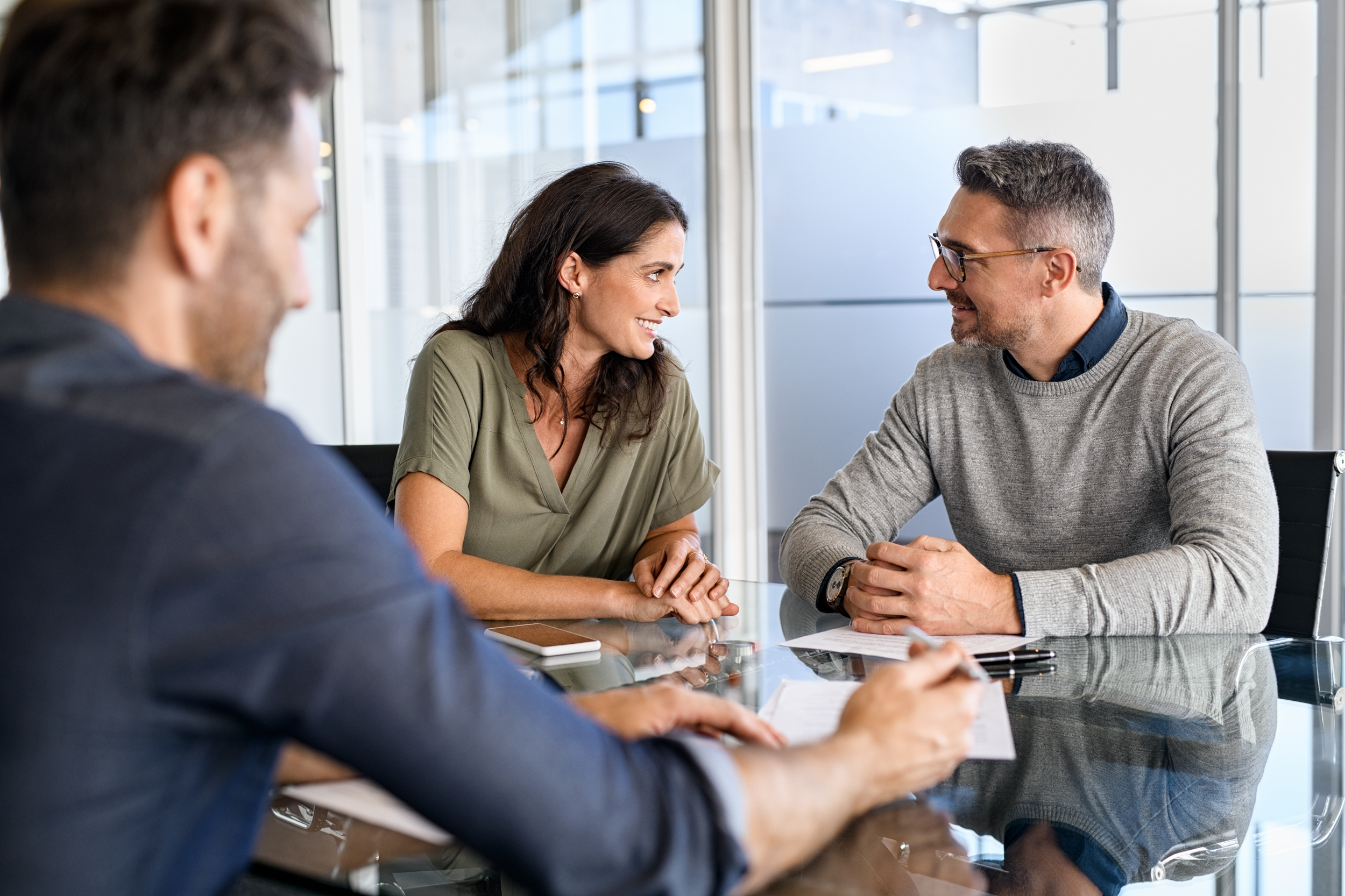 mature couple in an insurance broker office smiling