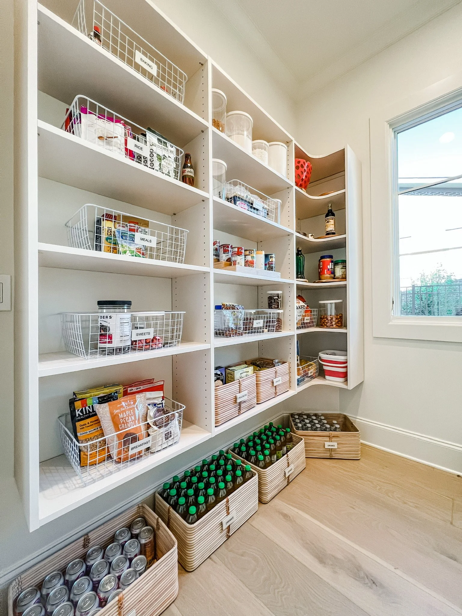 Organized pantry shelves with labeled bins and grouped food categories