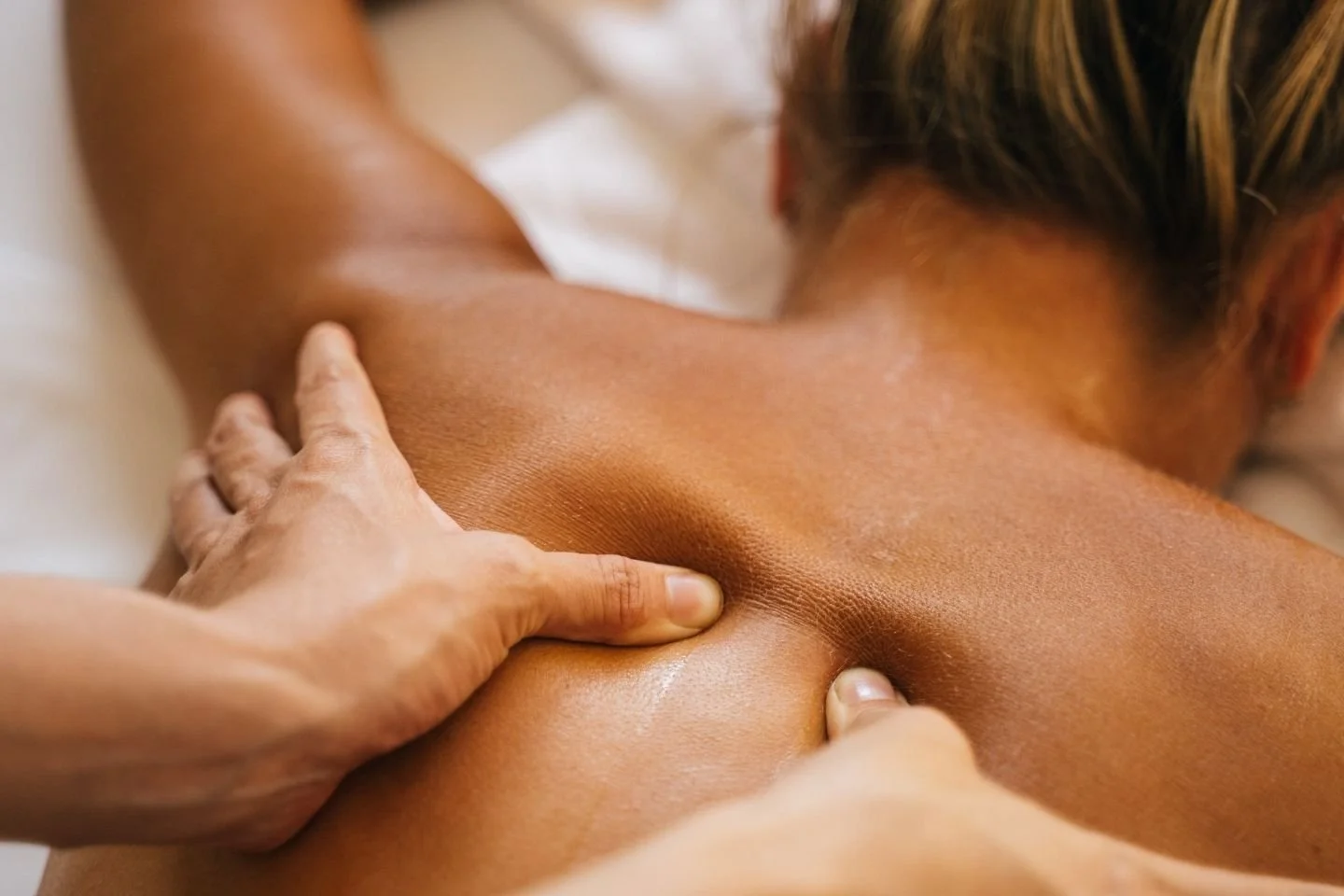 A person relaxing while a professional massages their back