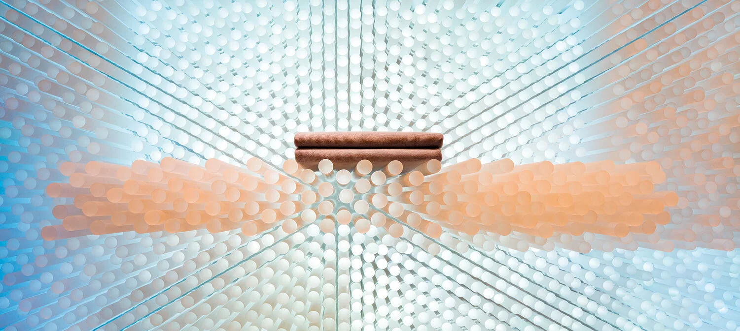 A series of peach and teal colored cylindrical rods protruding from the wall