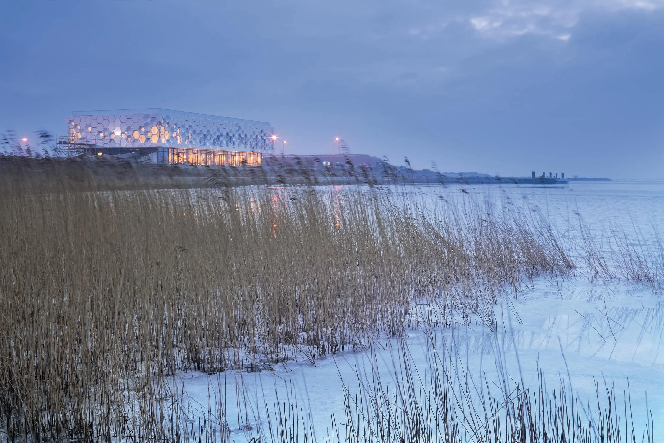 A far away view of the Afsluitdijk Wadden Center Kornwerderzand across from the iced cover waters