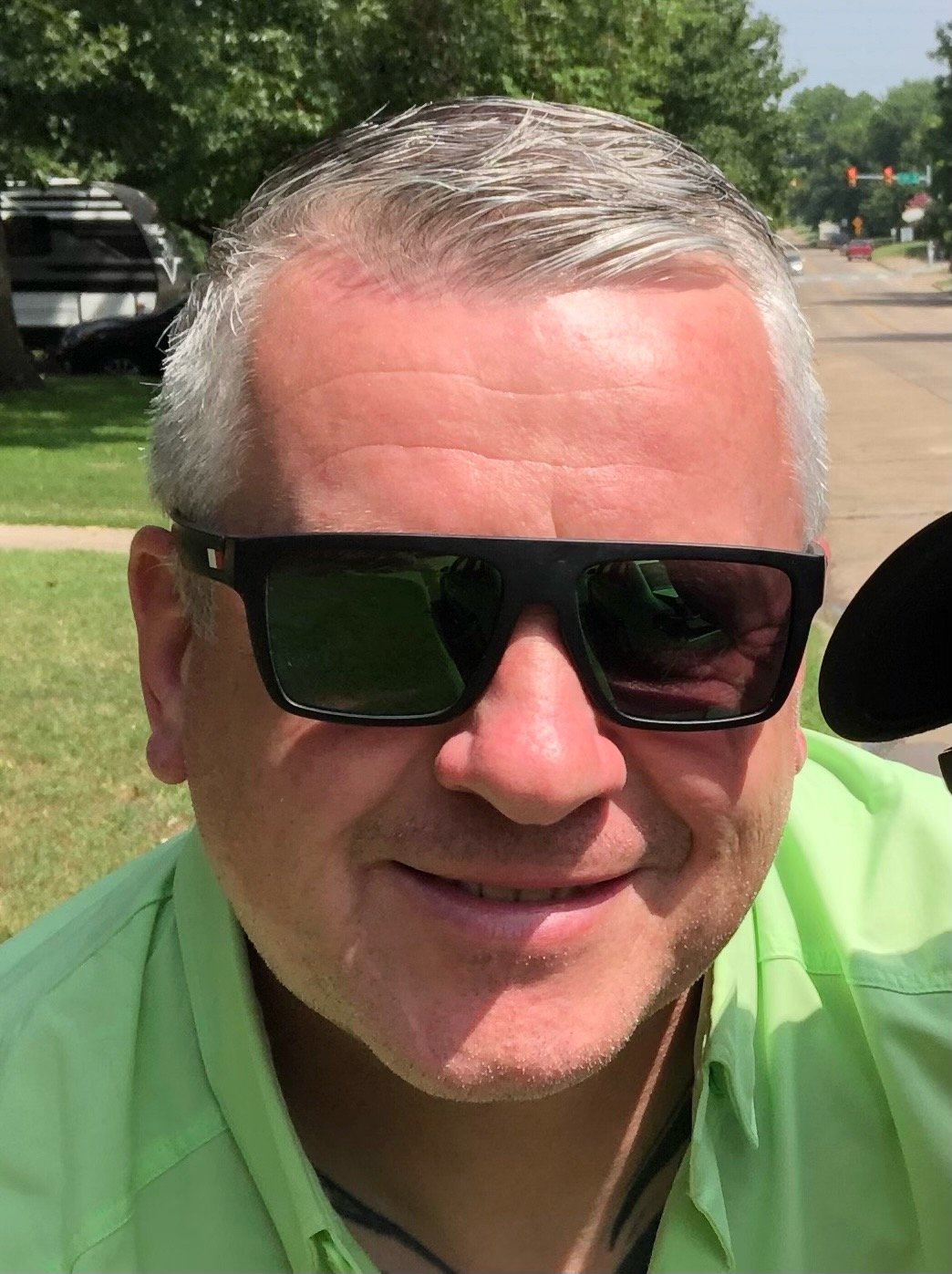 Man with sunglasses smiling outdoors