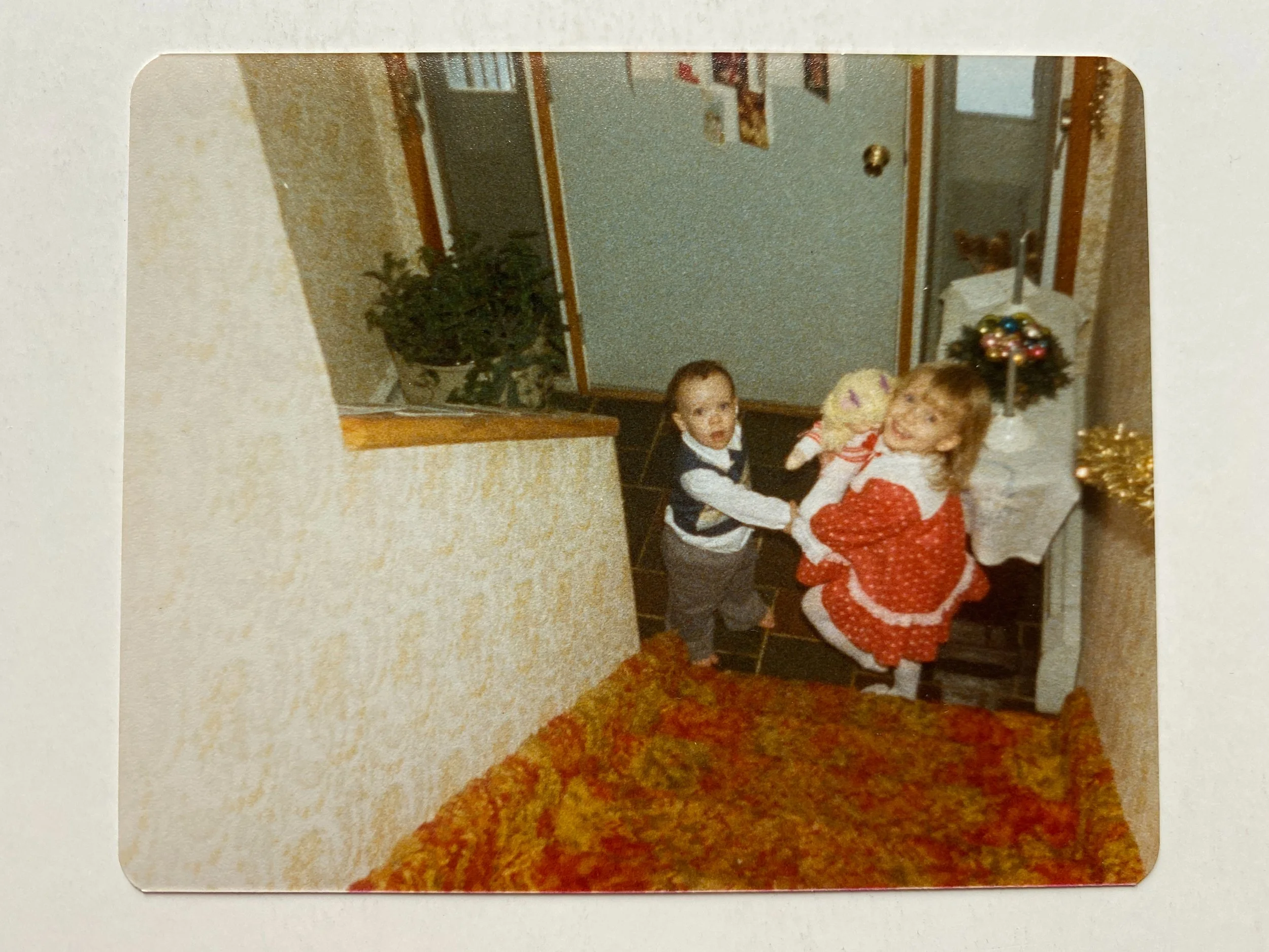 Christmas sibling photo walking down the stairs.