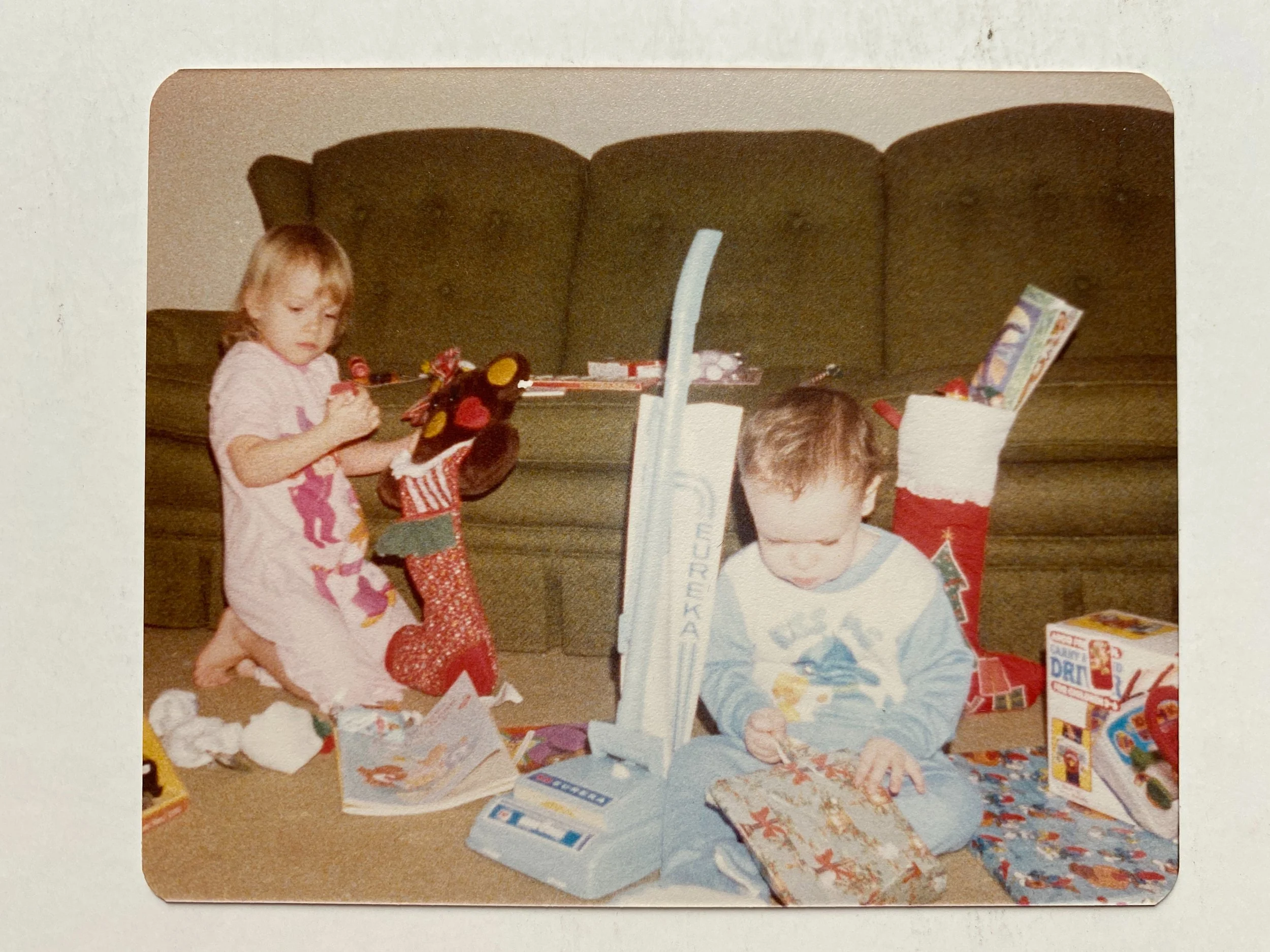 Children opening holiday gifts, a candid moment that becomes part of their family story.