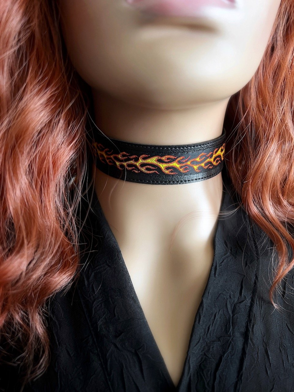 One inch wide black vegan leather choker base with red yellow and orange flame jacquard ribbon. Piece is adjustable and closes in back with black metal hook. Tags goth punk rock metal biker chunky