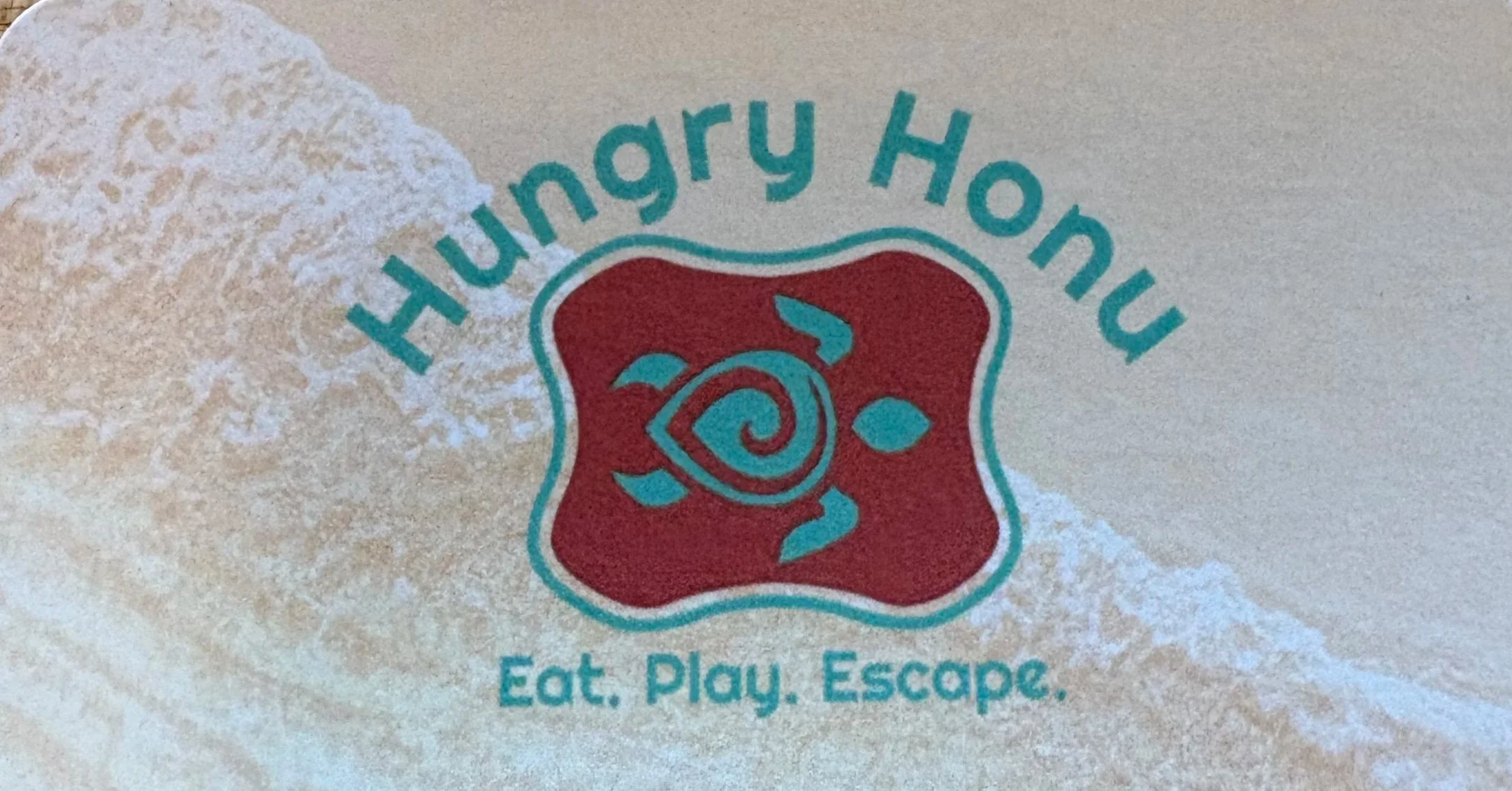 Close-up of a dessert wrapper with the logo of Harry Hoon and the slogan 'Eat. Play. Escape.'