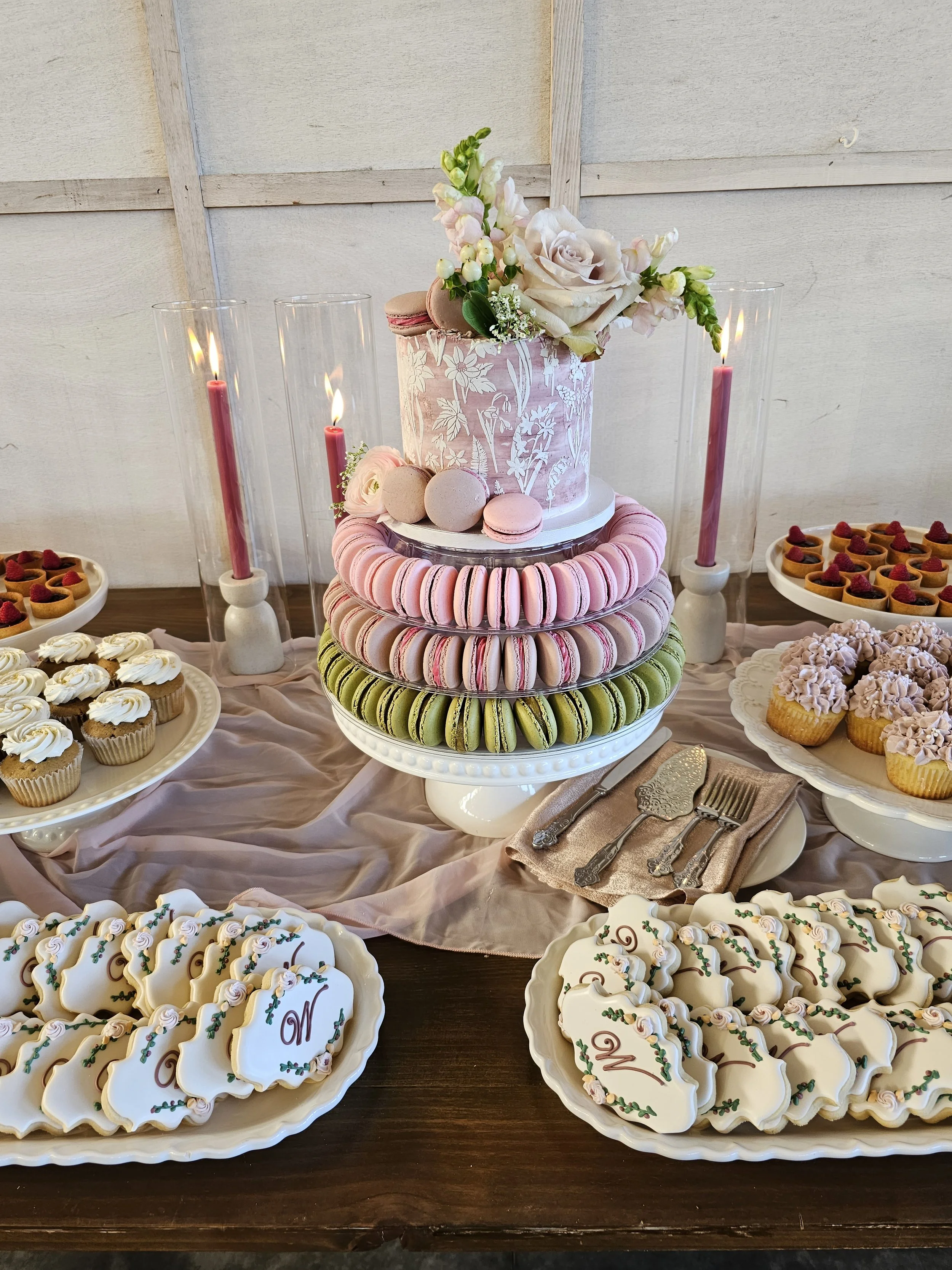   Portland Oregon wedding dessert table featuring a floral wedding cake, macarons, custom cookies, and mini desserts styled for a romantic reception.  
