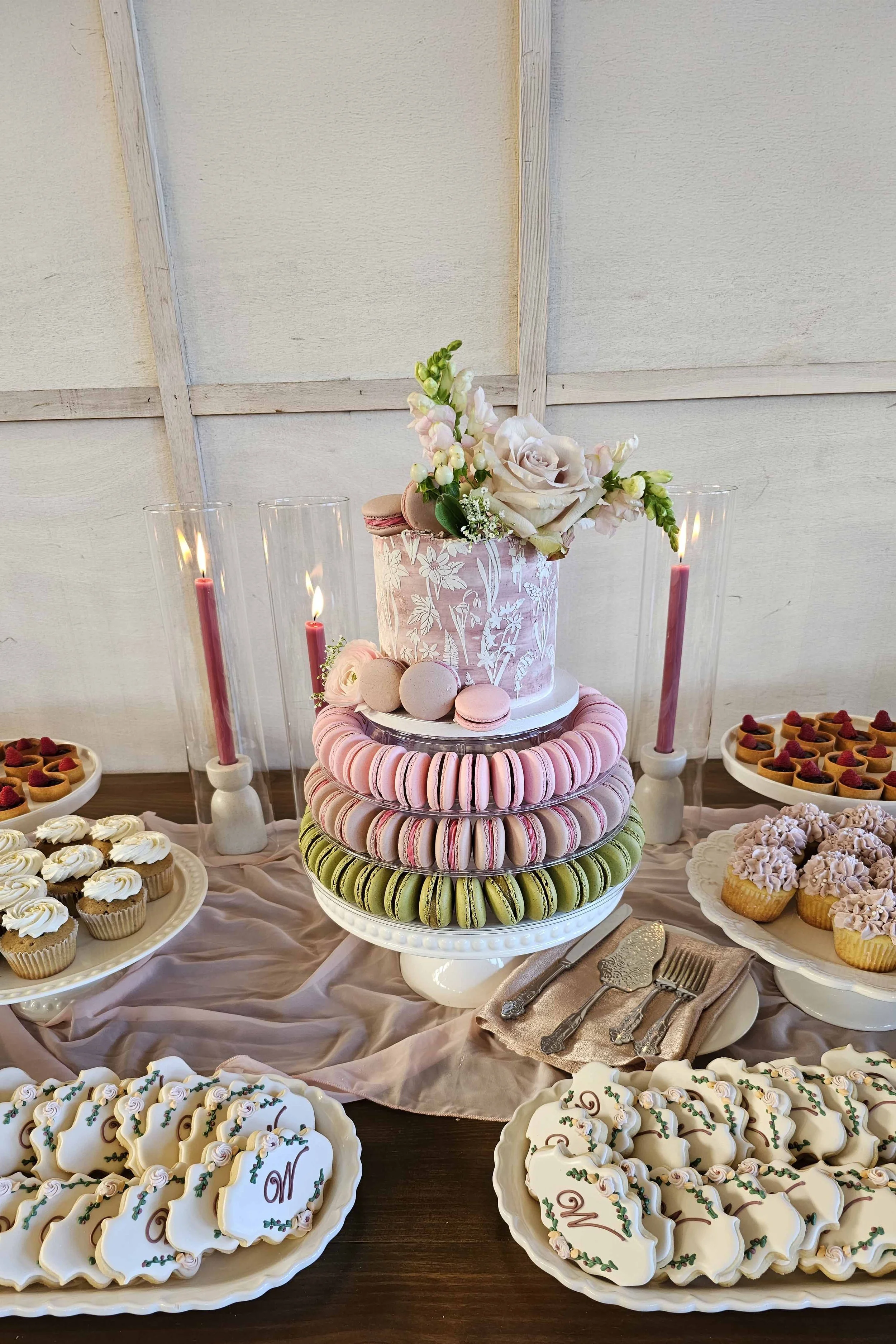   Portland Oregon wedding dessert table featuring a floral wedding cake, macarons, custom cookies, cupcakes, and mini desserts styled for a romantic reception.  