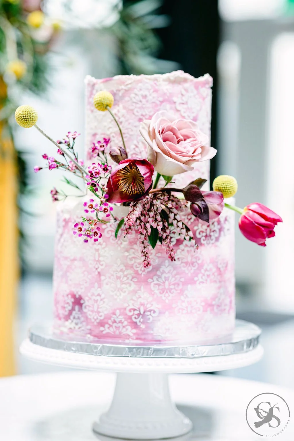   Luxury Portland Oregon wedding cake with pink patterned buttercream and fresh floral design, displayed as an elegant reception centerpiece.  