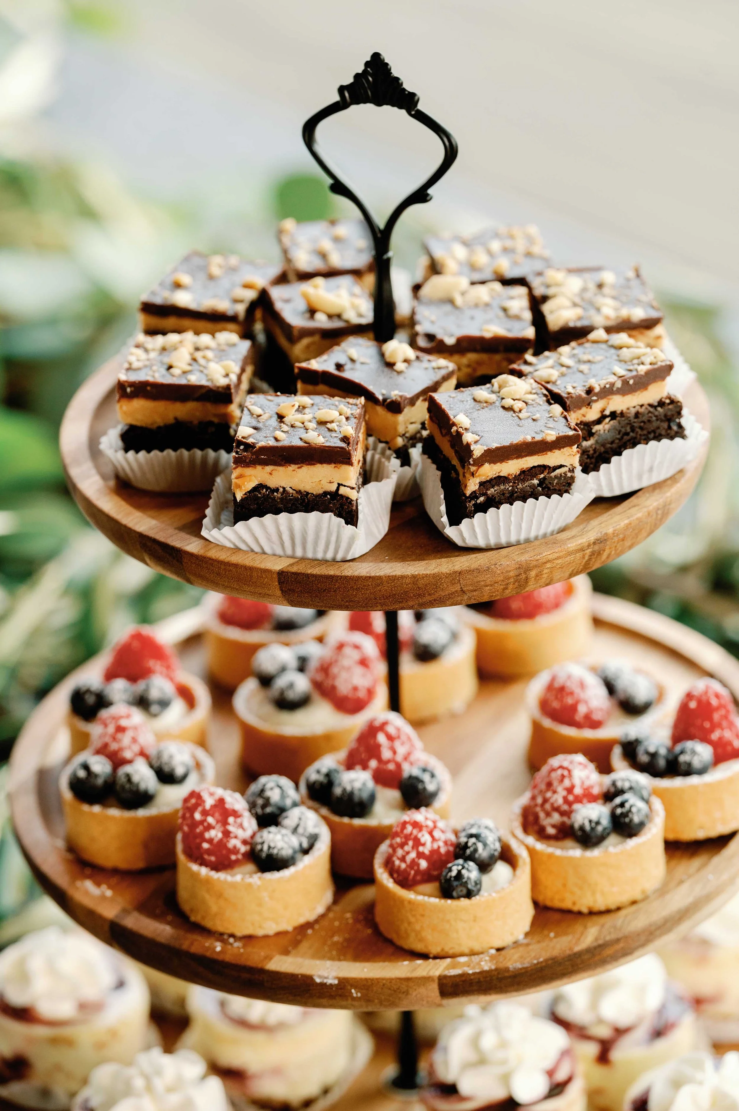   Portland Oregon wedding dessert table featuring mini desserts, berry tarts, and layered bars displayed on an elegant tiered stand.  