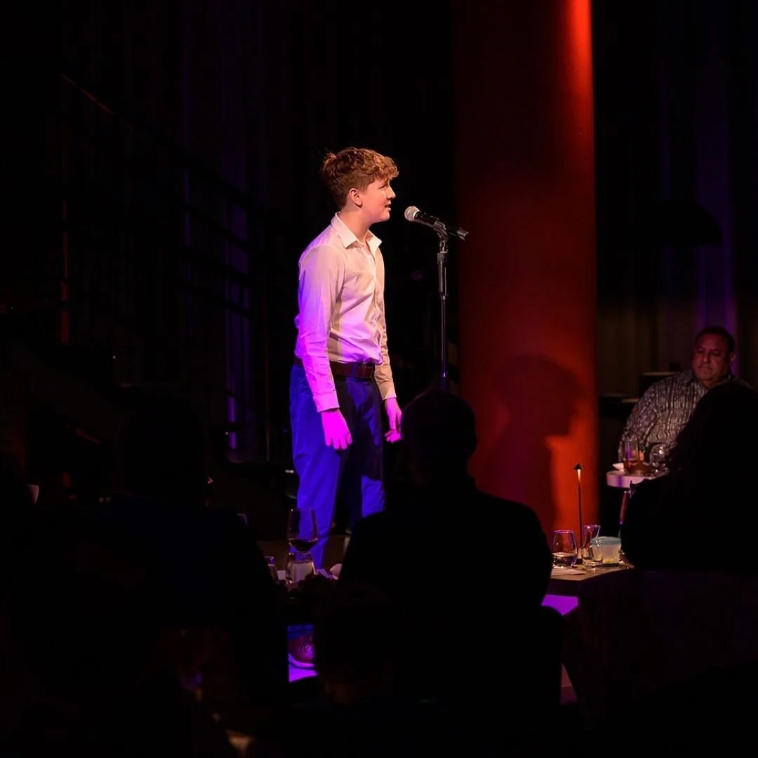 Image of a boy singing into a microphone