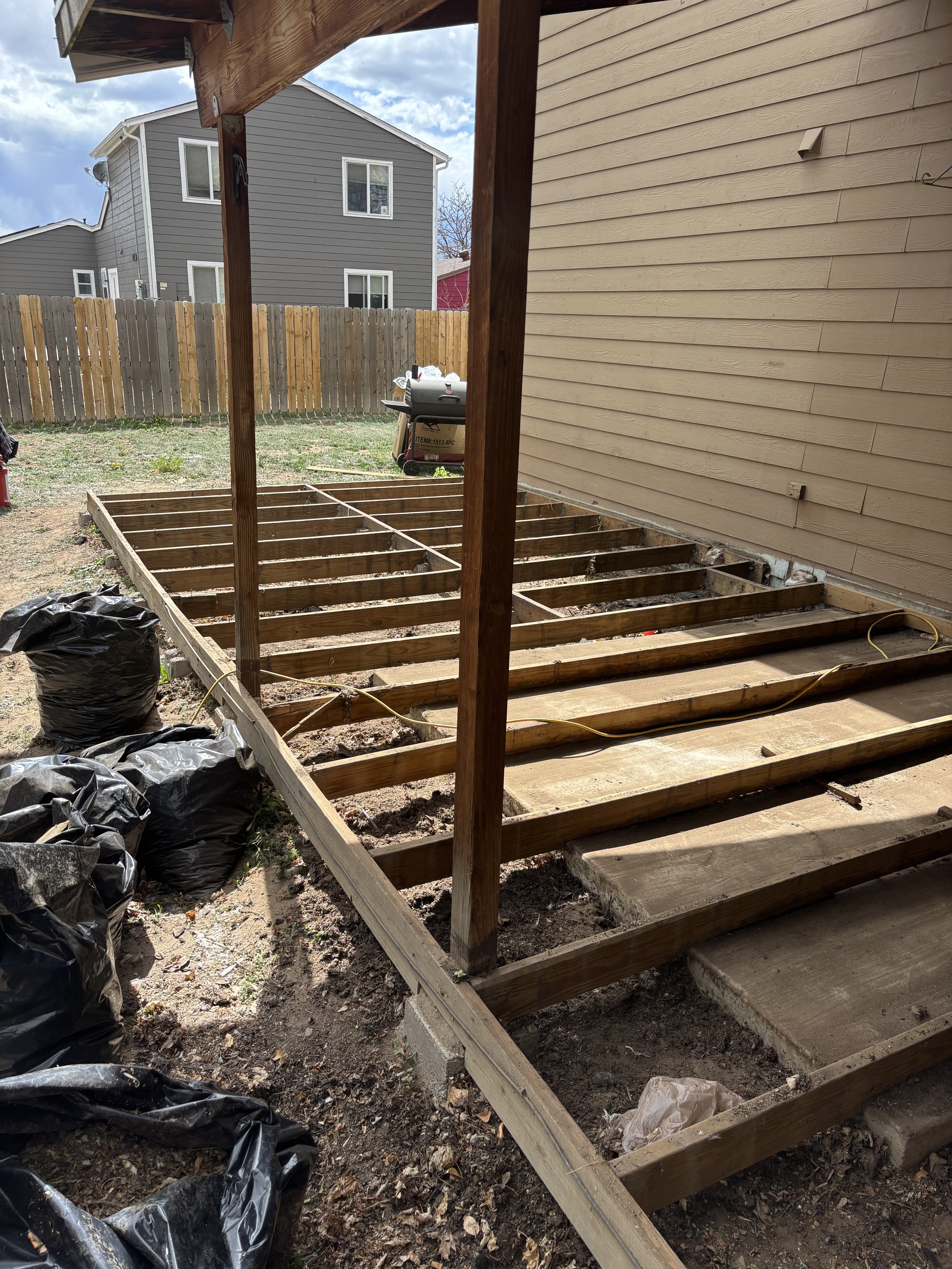 Backyard and outdoor home improvement by Otto Custom Builders, featuring raised wooden garden beds, a covered patio, privacy fencing, and outdoor living space. Residential remodeling, exterior improvements, and carpentry servicesin Denver, Centennial