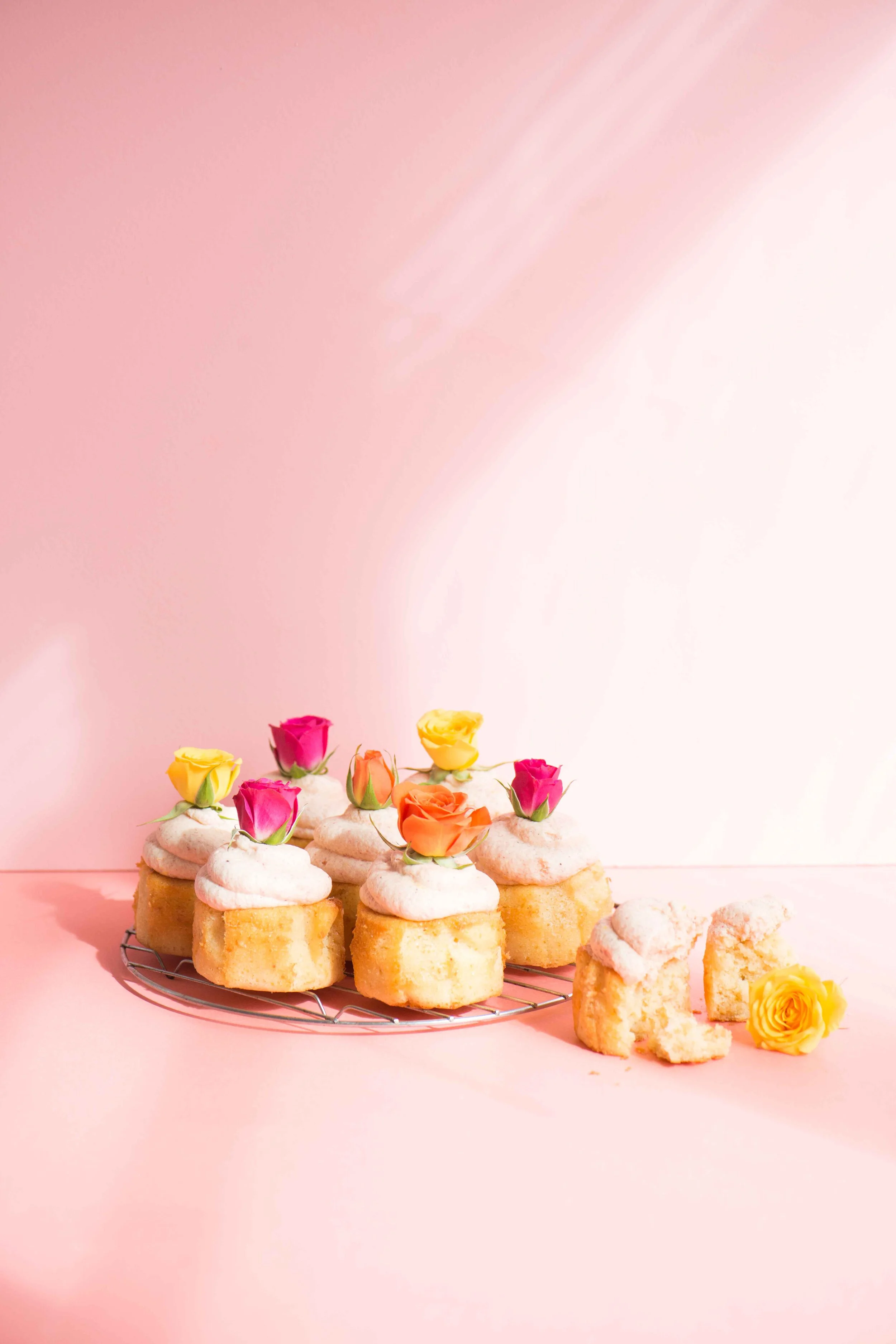 Cupcakes colorful edible flowers on a pink background.