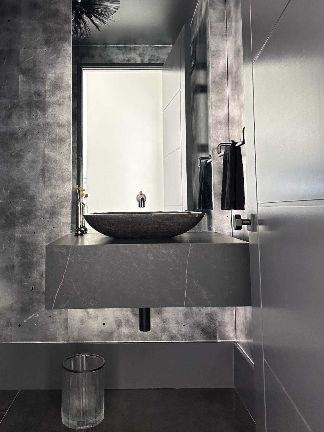 A DBI-ified glow up::
Stone-clad floating vanity, metallic silver leaf walls, and gunmetal fixtures&mdash;proof that a powder room can be seriously statement-making.

#darabeitlerinteriors 
#powderroomgoals 
#luxuryi̇nteriors 
#bathroomdesignideas 
#