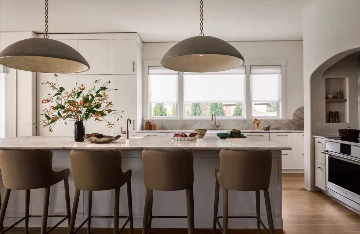 Soft curves, warm finishes, and a palette rooted in quiet luxury. This bespoke kitchen was designed to feel both elevated and effortless &mdash; where sculptural lighting, custom cabinetry, and natural stone come together to create a space that invit