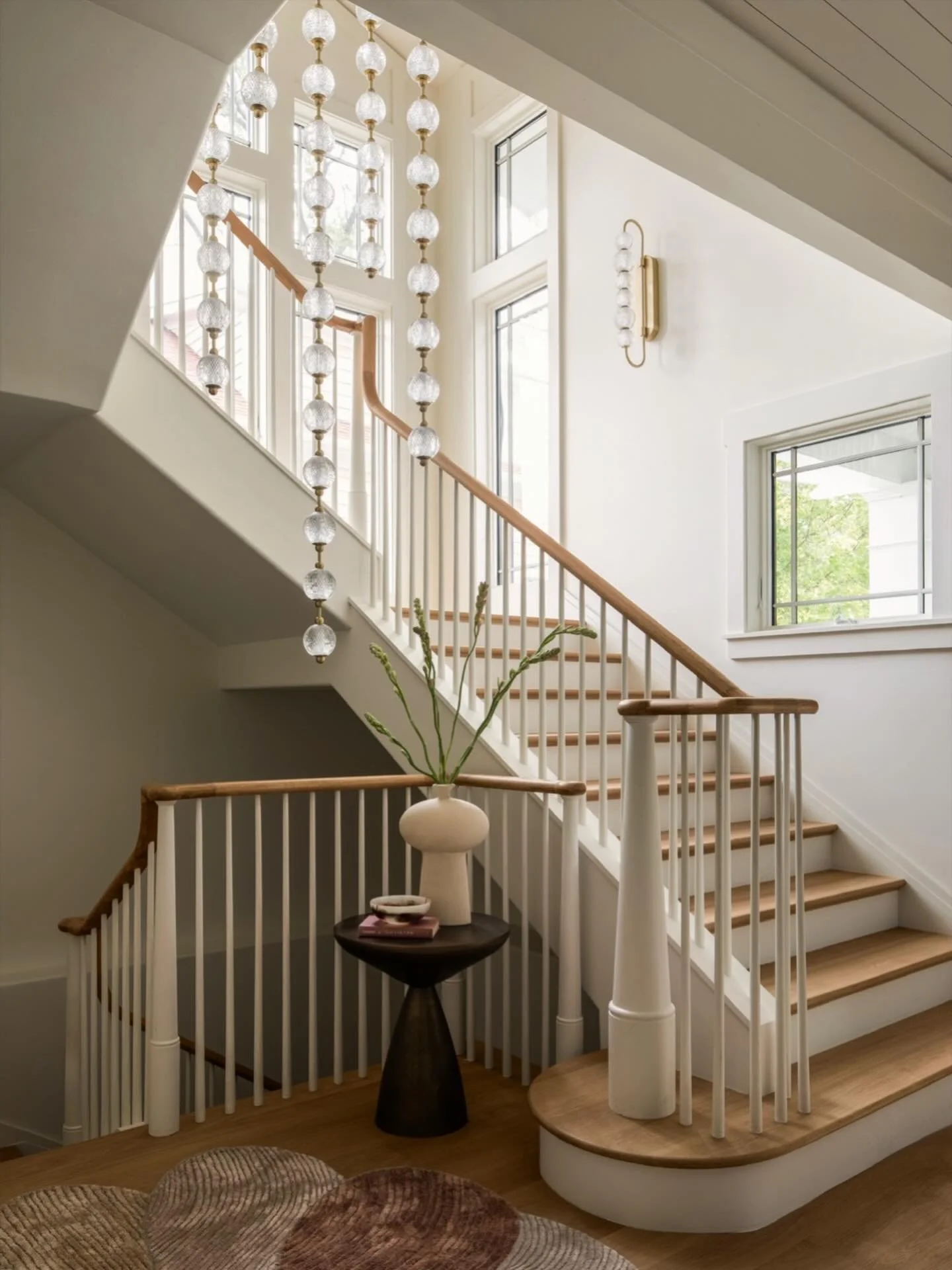 Layers of light, sculptural detail, and a staircase designed to feel as beautiful as it is functional. From the custom millwork to the cascading glass fixtures, every element was thoughtfully curated to create a sense of quiet drama and effortless fl