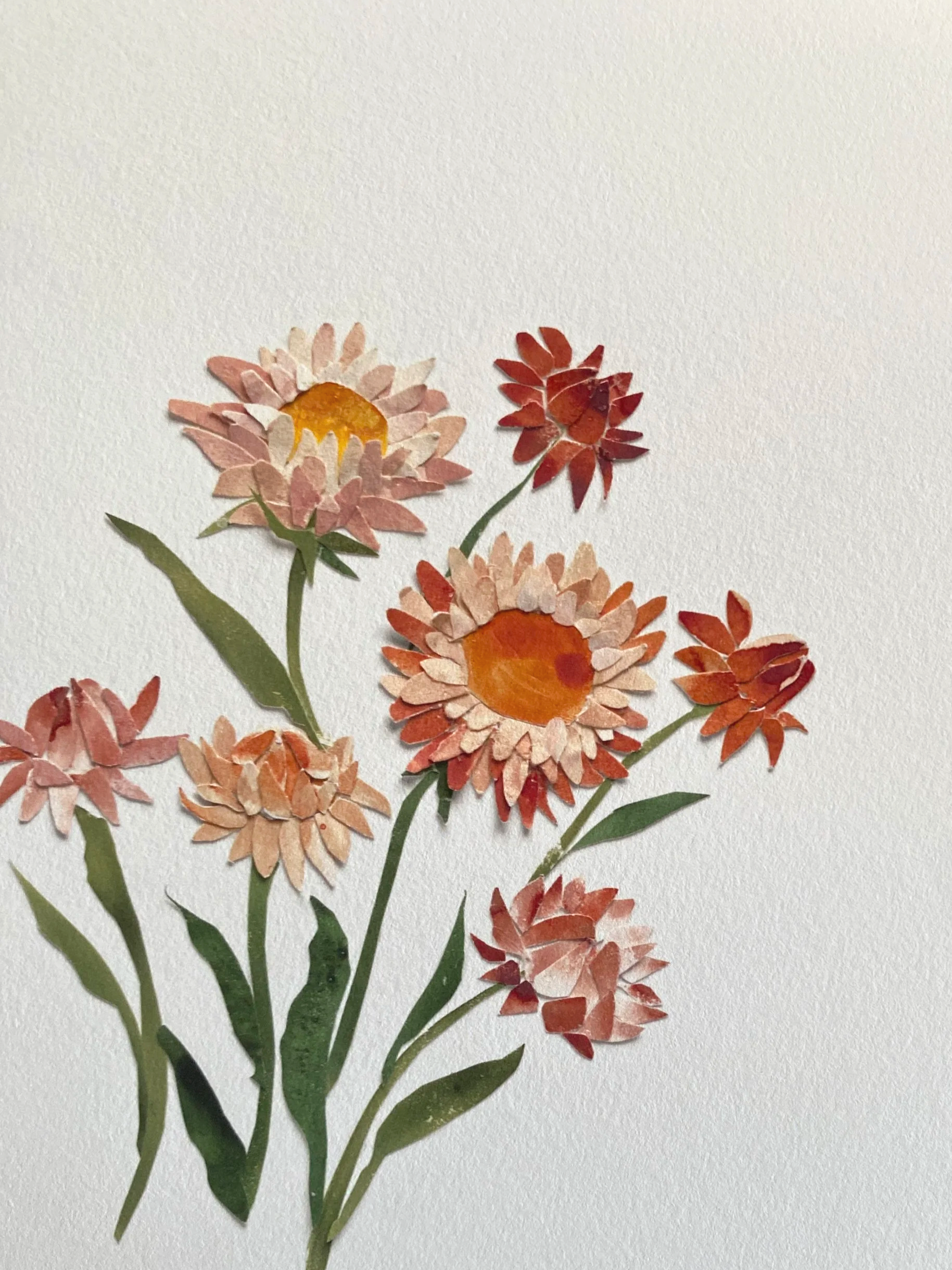 Colorful collage of paper flowers with green leaves on a white background.