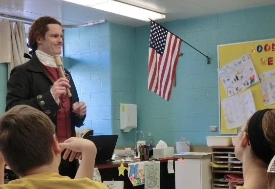 TJ in classroom with kids rectangle.jpeg