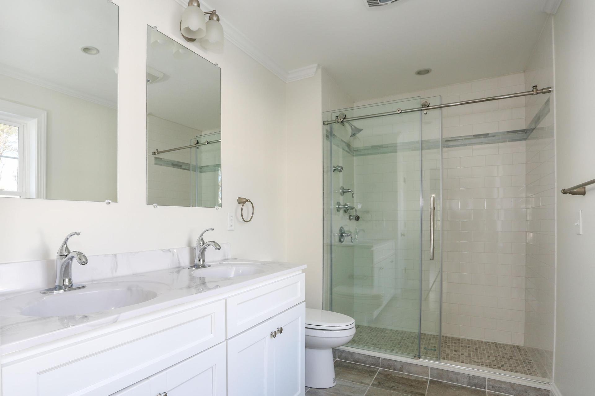 Master bath with quartz countertops and glass shower.jpeg