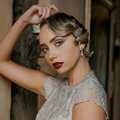 Vintage-inspired beauty portrait with polished makeup, softly sculpted waves and a deep red lip.