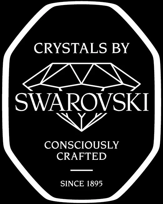 Label with text 'Crystals by Swarovski, Consciously Crafted, Since 1895' and a stylized geometric illustration of a crystal.
