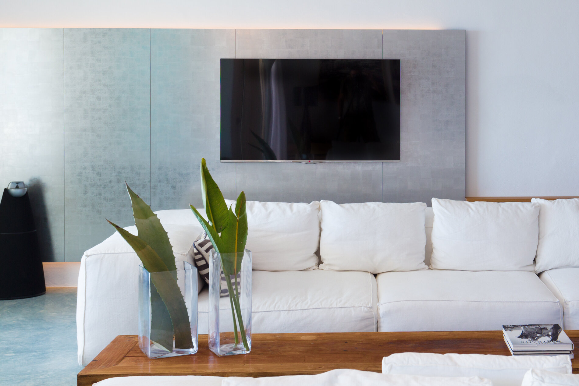 Living room with big cosy white couch and touches of green