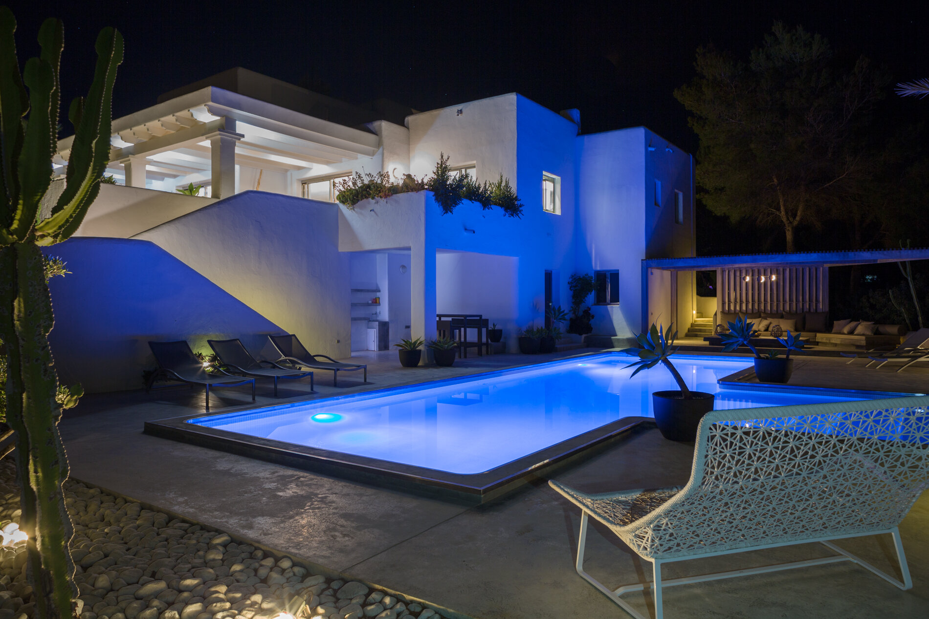 Night view of the pool and villa blue light coming from the pool 