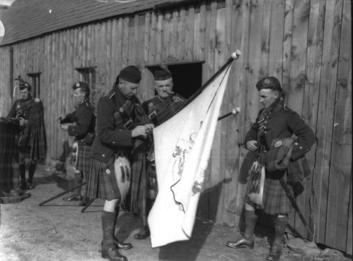 Honour guard checking the colours including the Invercauld Highlanders waiting for duty. 1937