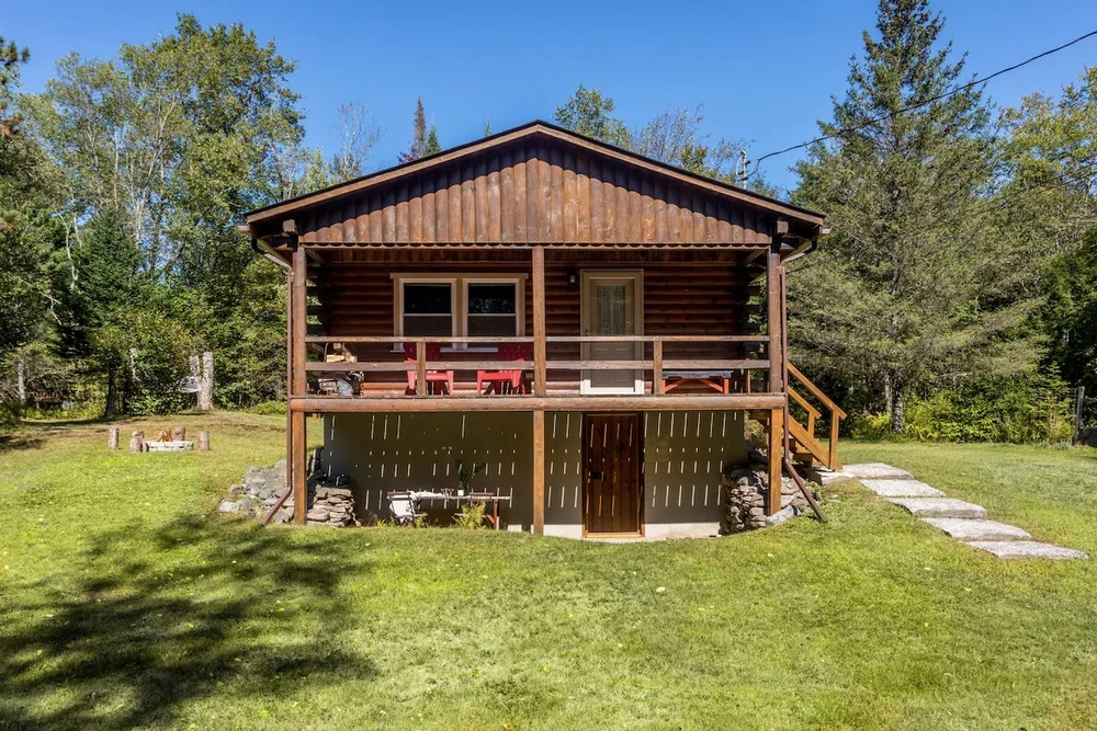 Classic Catskills log cabin with wood stove on a quiet historic road in