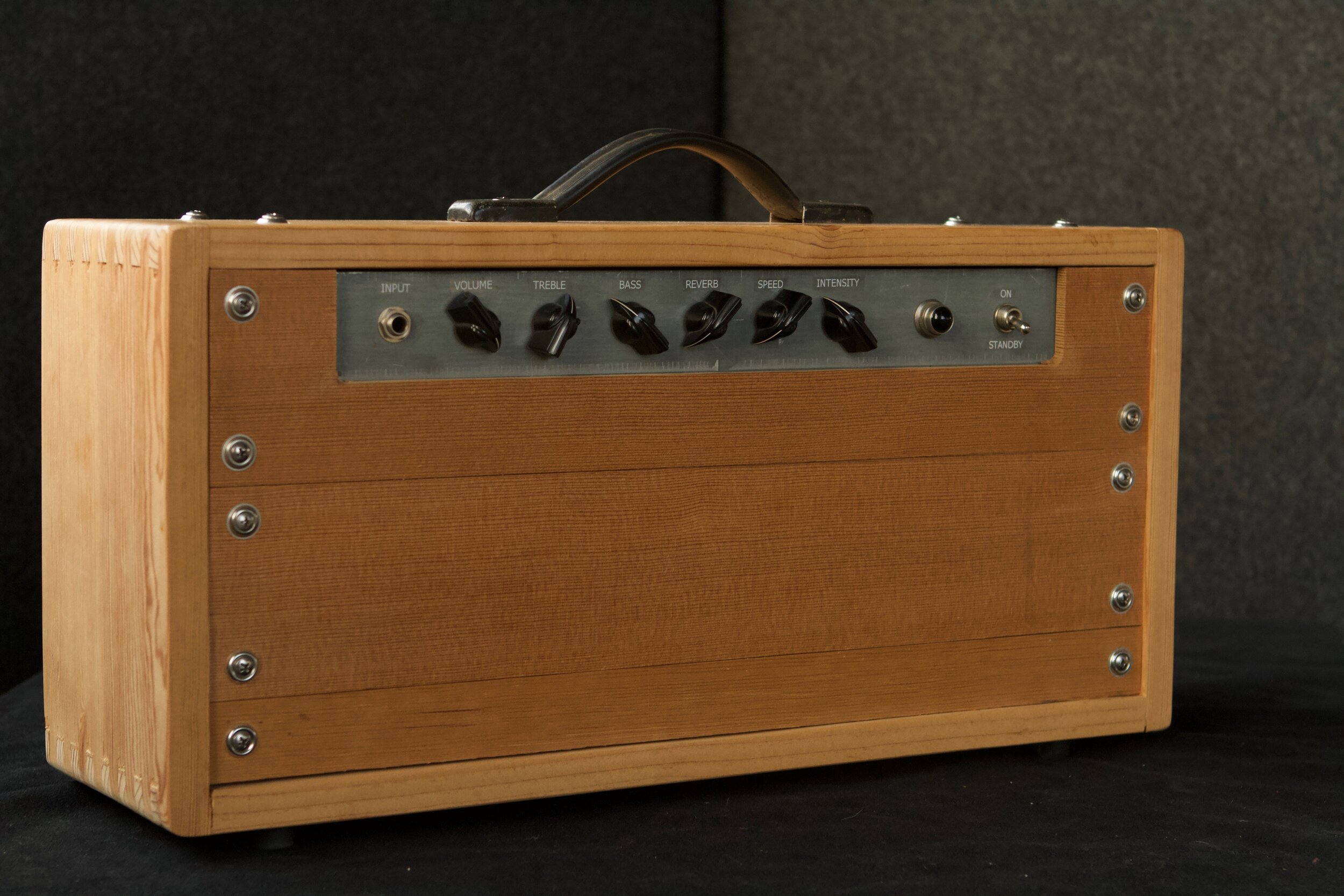 A tube amp built on a salvaged organ chassis with a pine wood case. The amp design is inspired by the Fender Princeton Reverb, including the blackface reverb and the Princeton Tremolo that modulates the power tube bias.