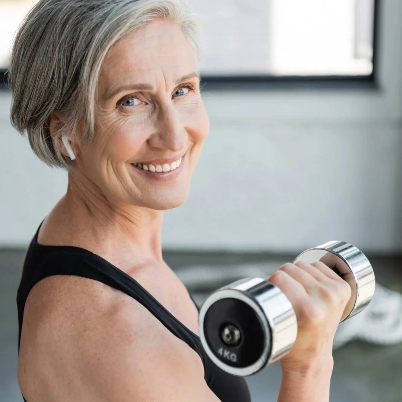 smiling-senior-woman-wireless-earphone-listening-music-working-out-with-dumbbell-gym.jpg