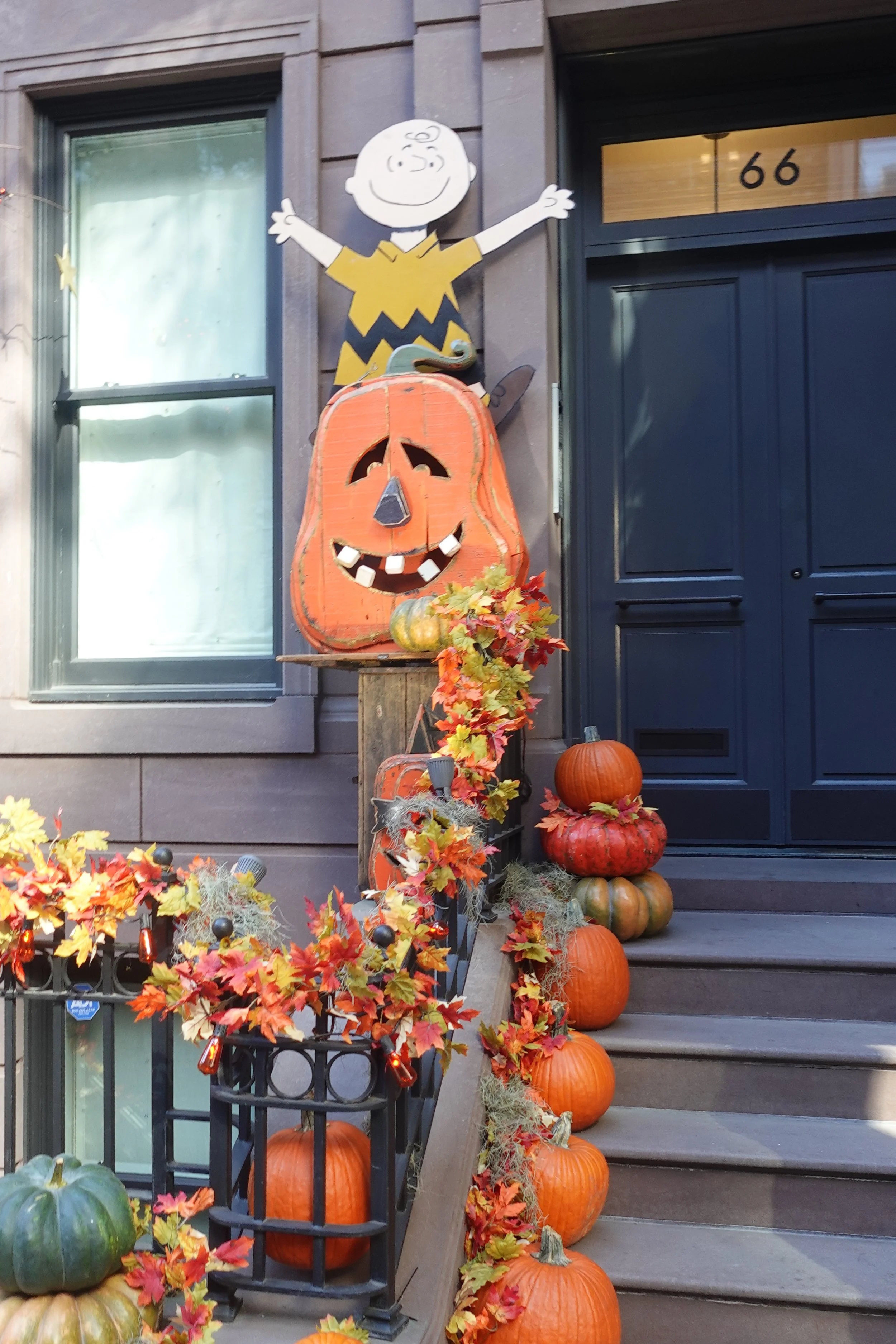  brownstone dressed up for Halloween with jack-o'-lanterns and string lights 