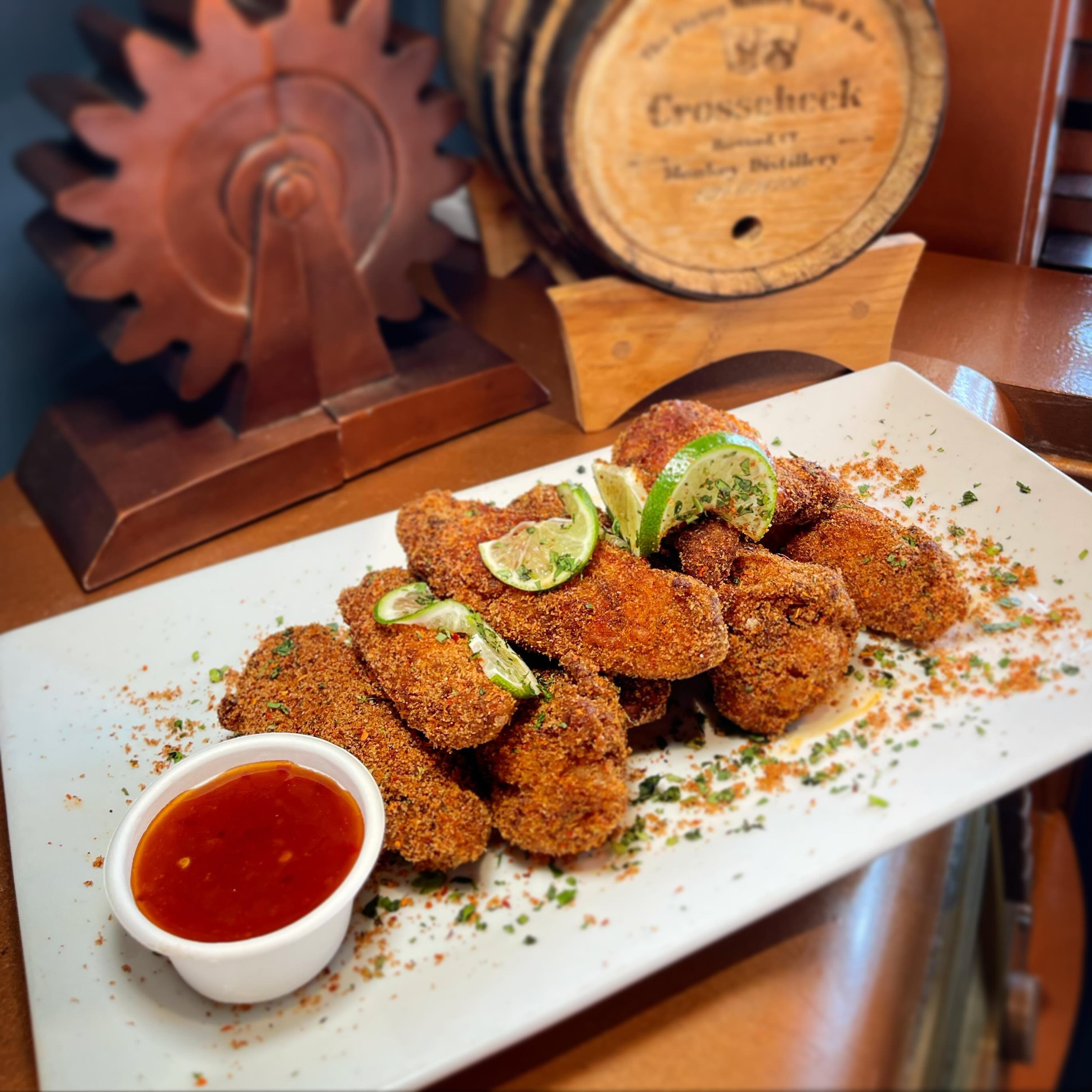 Chili Lime Wings- No Monkeying around with these jumbo wings! Baked in our secret monkey rub, then fried crispy. Tossed with a house-made chili lime rub, served with a side of sweet chili