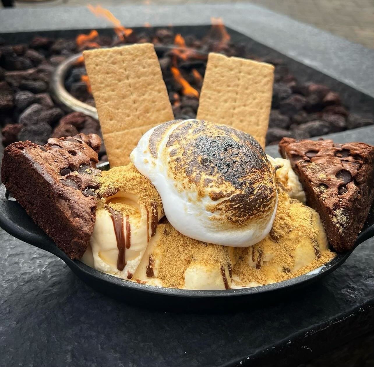 Camp Fire Smore Sundae- Warm brownie topped with vanilla bean ice cream, Finished with caramelized whipped marshmallow, nutella drizzle and honey graham crackers