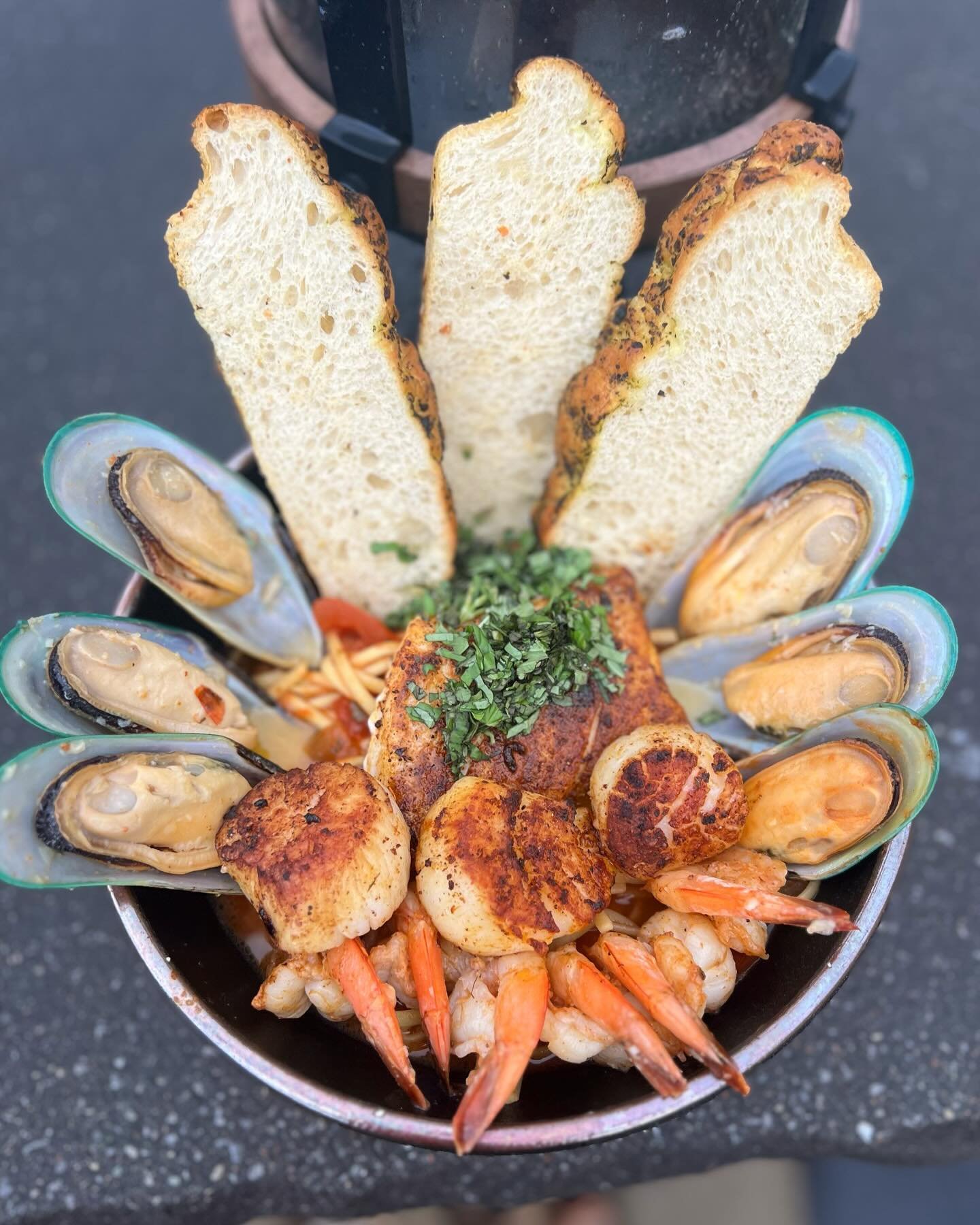 Monkey Cioppino- Pan-seared sea scallops, shrimp, mussels and cod loin tossed in an aromatic tomato broth with hints of basil and cayenne, over linguine pasta. Served with ciabatta bread (Spicy)